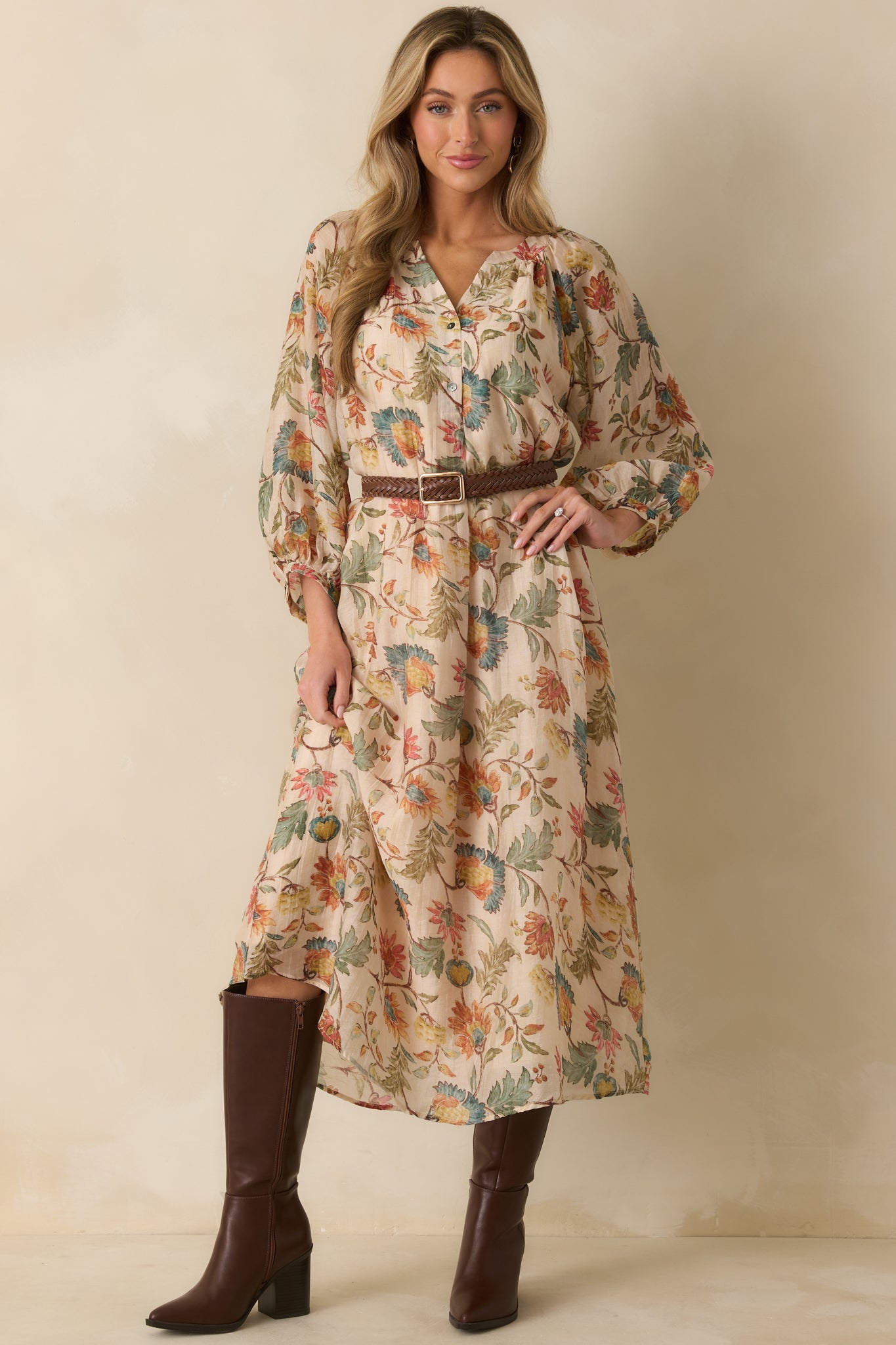 Soft ecru maxi dress patterned with colorful florals, featuring long sleeves and a loose, airy silhouette.