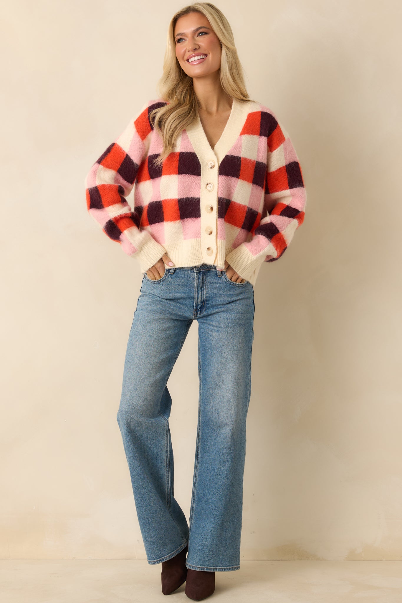 The soft fuzzy knit highlights the front button closure and ribbed trim along the cuffs, hem, and neckline.