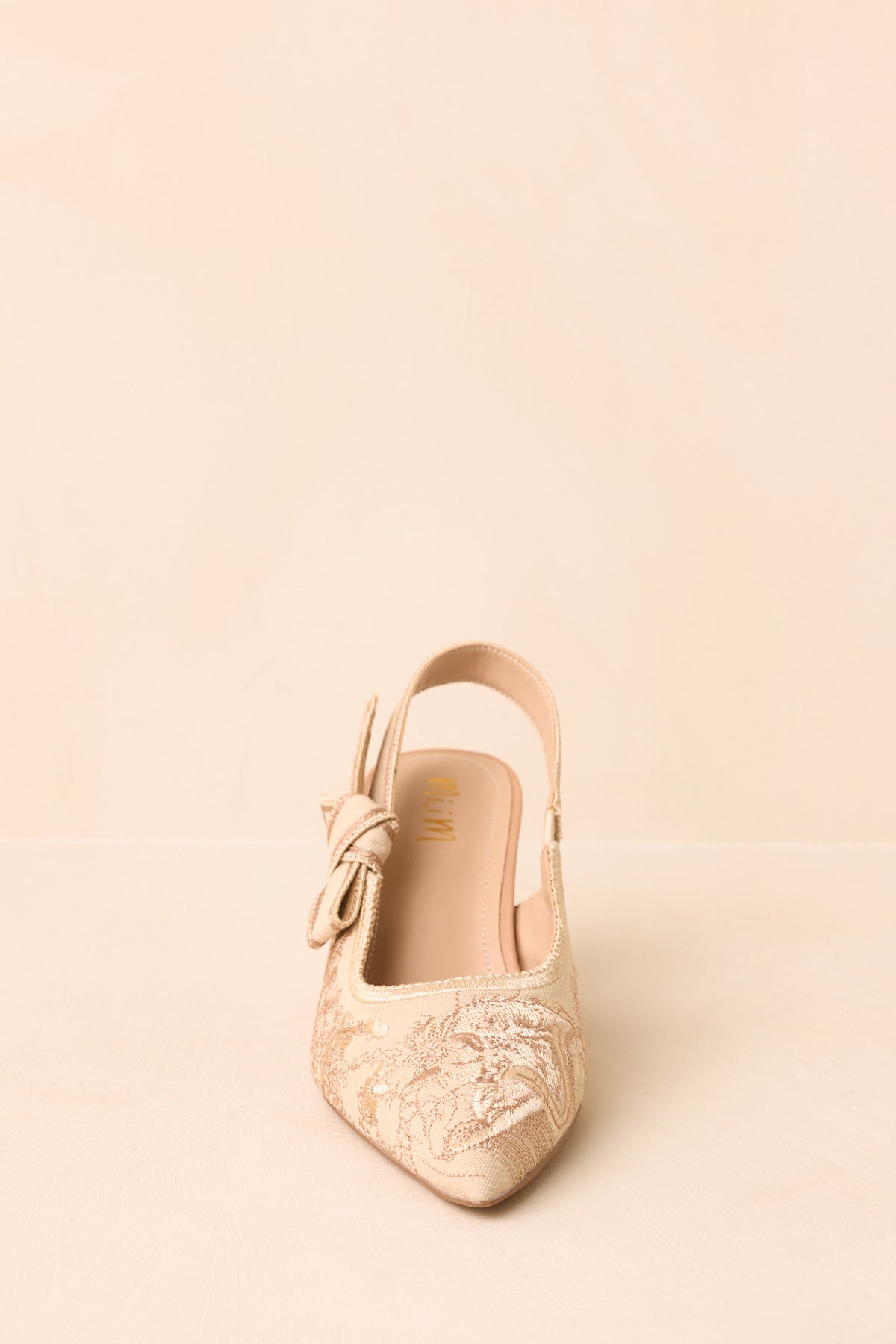 Soft gold embroidered slingbacks highlighting the streamlined pointed toe and supportive mid-height heel.