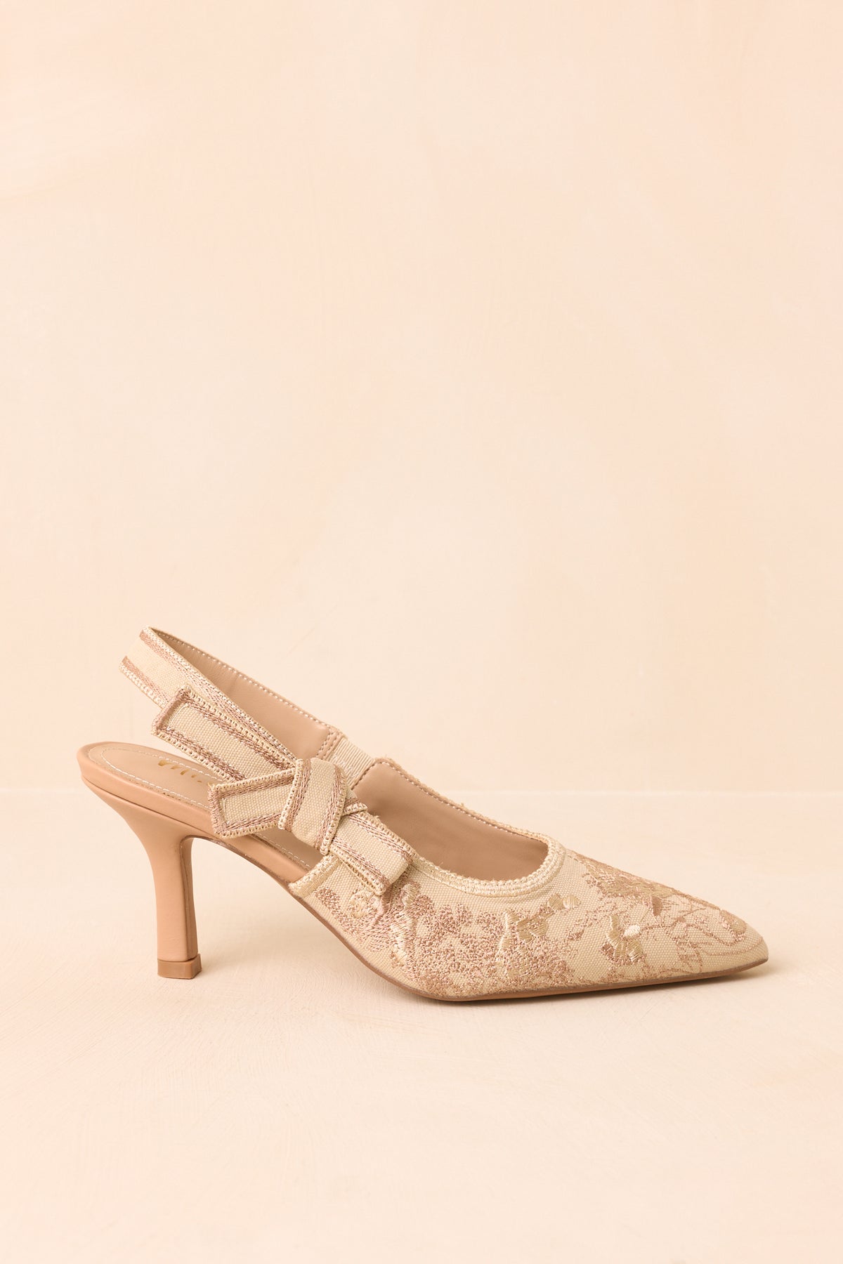 Soft gold slingback heels shown at an angle, highlighting the pointed toe and embroidered upper.