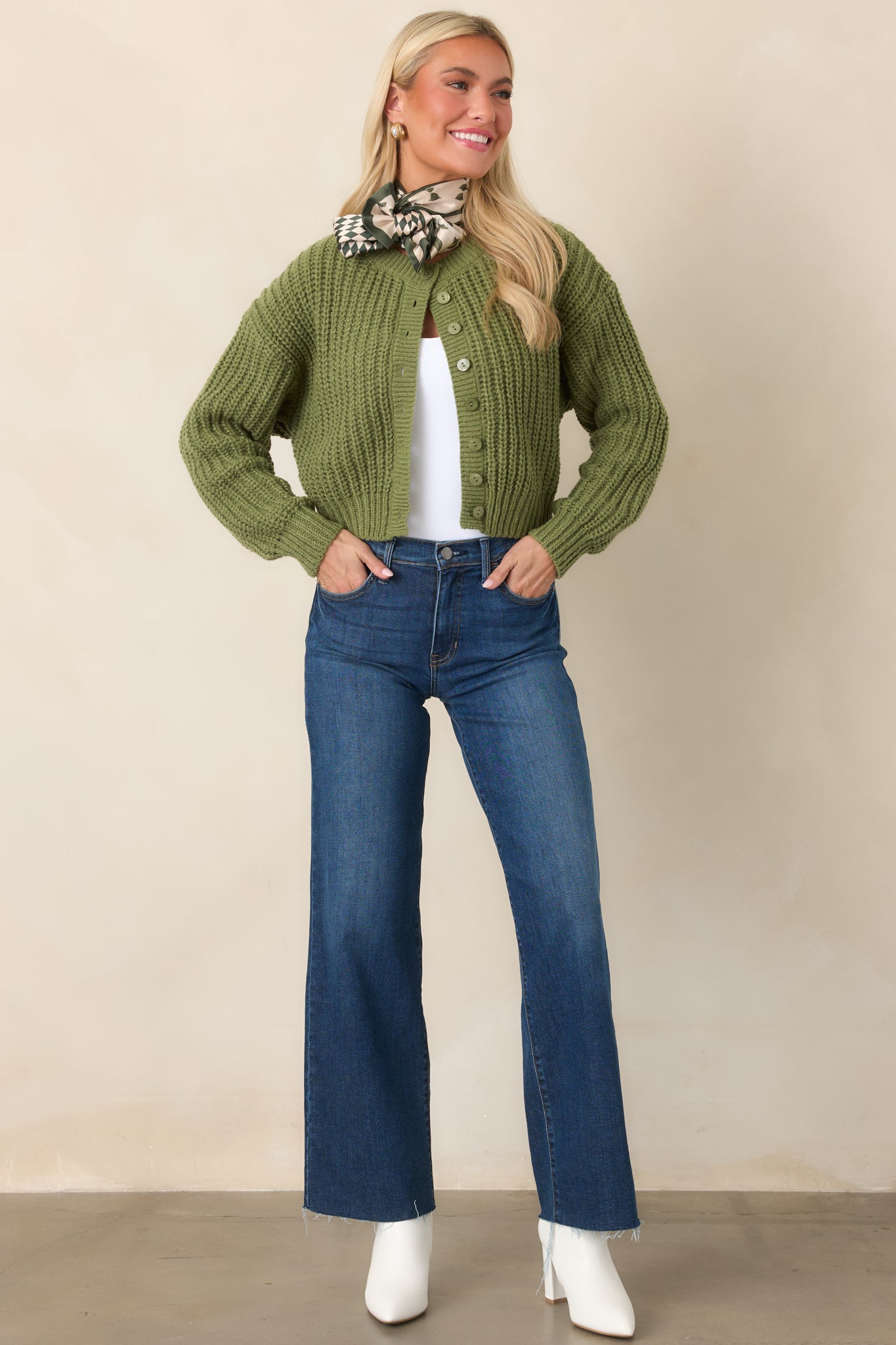 Soft green cropped cardigan featuring chunky cable-inspired knit detailing, a crew neckline, tonal marbled buttons, and long sleeves.