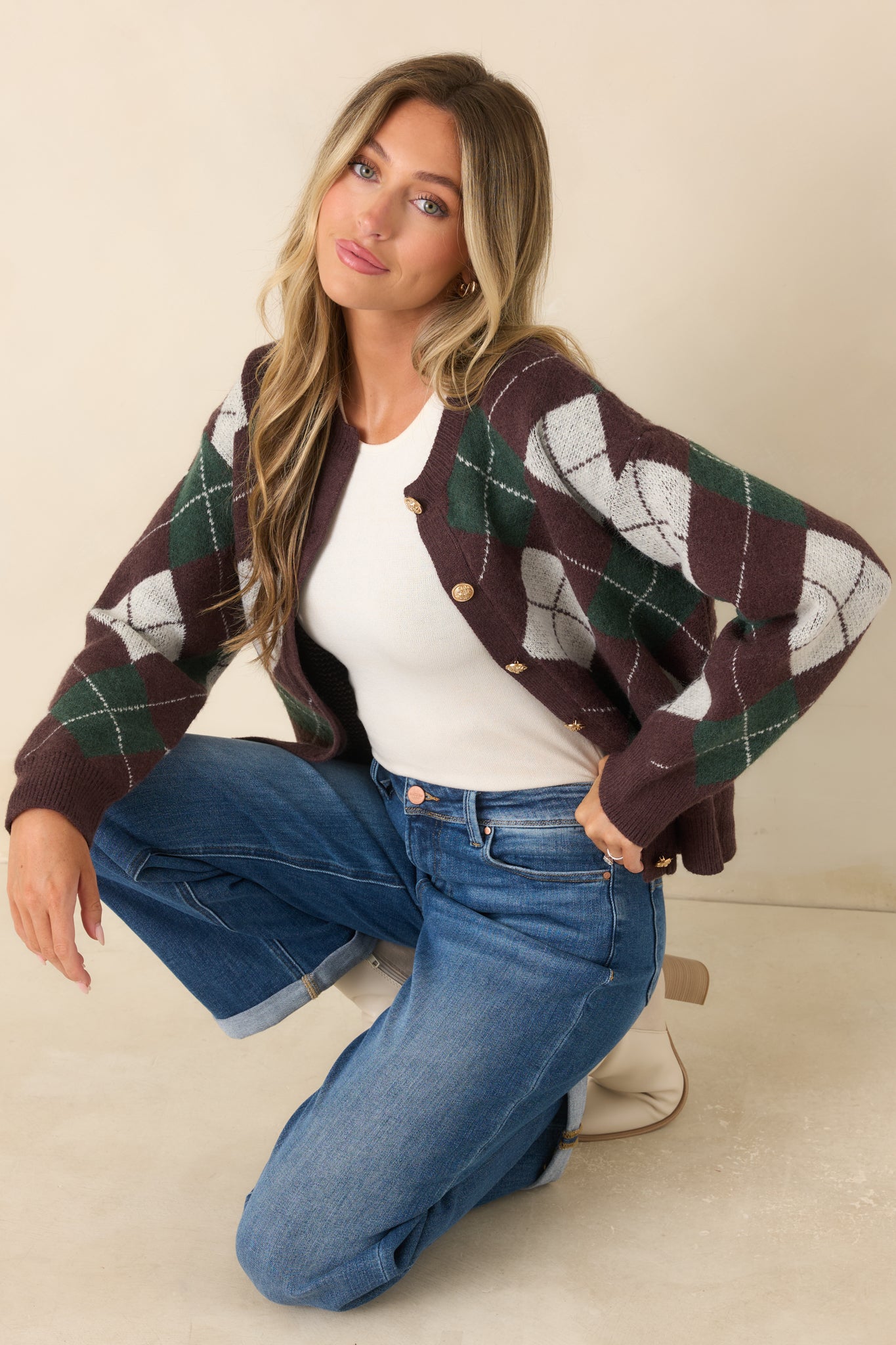 Soft knit cardigan showcasing a classic argyle pattern, ornate gold-tone buttons, ribbed trim, and an easy relaxed fit.