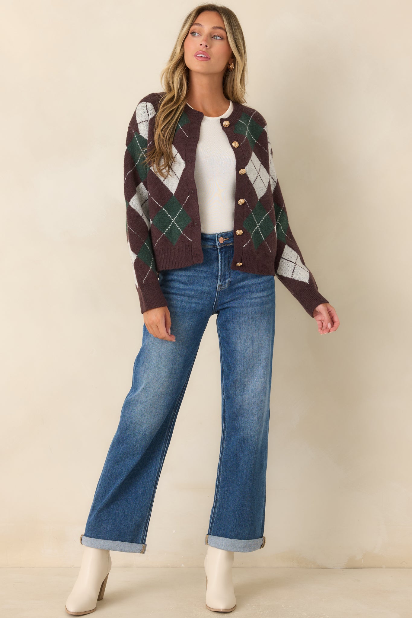 Soft knit argyle cardigan featuring a deep brown, hunter green, and ivory diamond pattern, round neckline, functional gold-tone buttons, ribbed trim, and a relaxed silhouette.