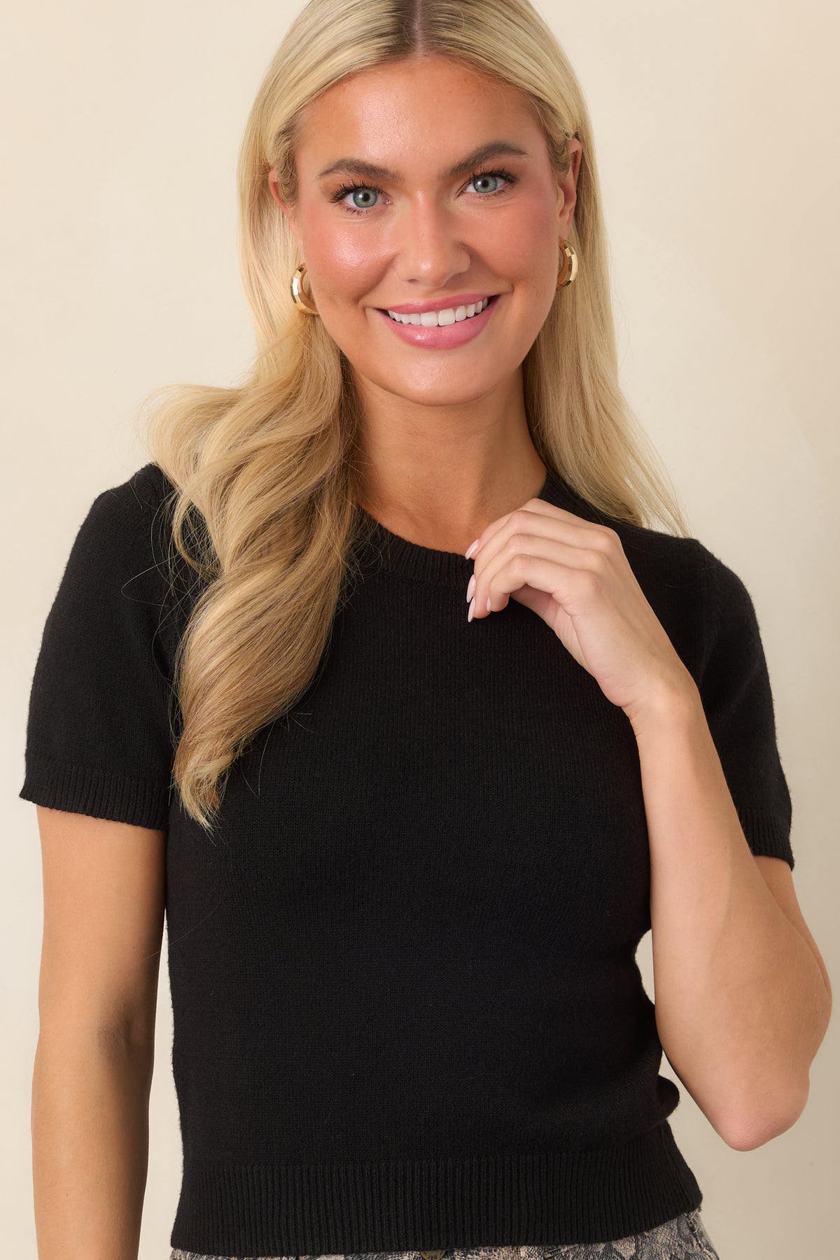 Soft knit fabric frames the crew neckline and transitions into clean short sleeves with ribbed cuffs.