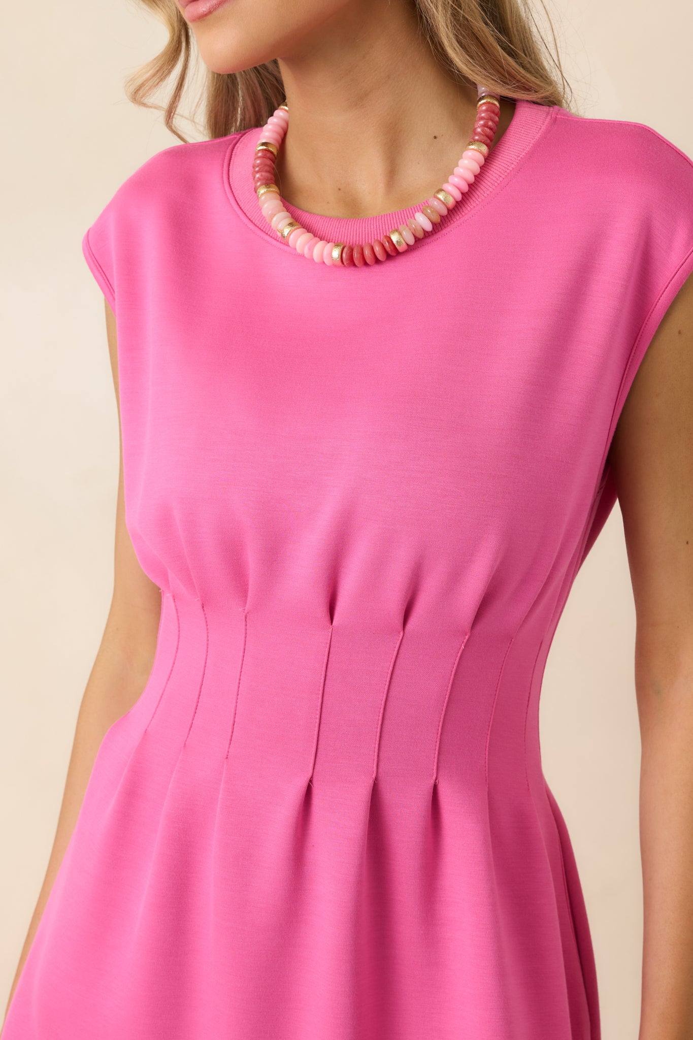 Soft knit fabric with subtle waist cinching and smooth texture.
