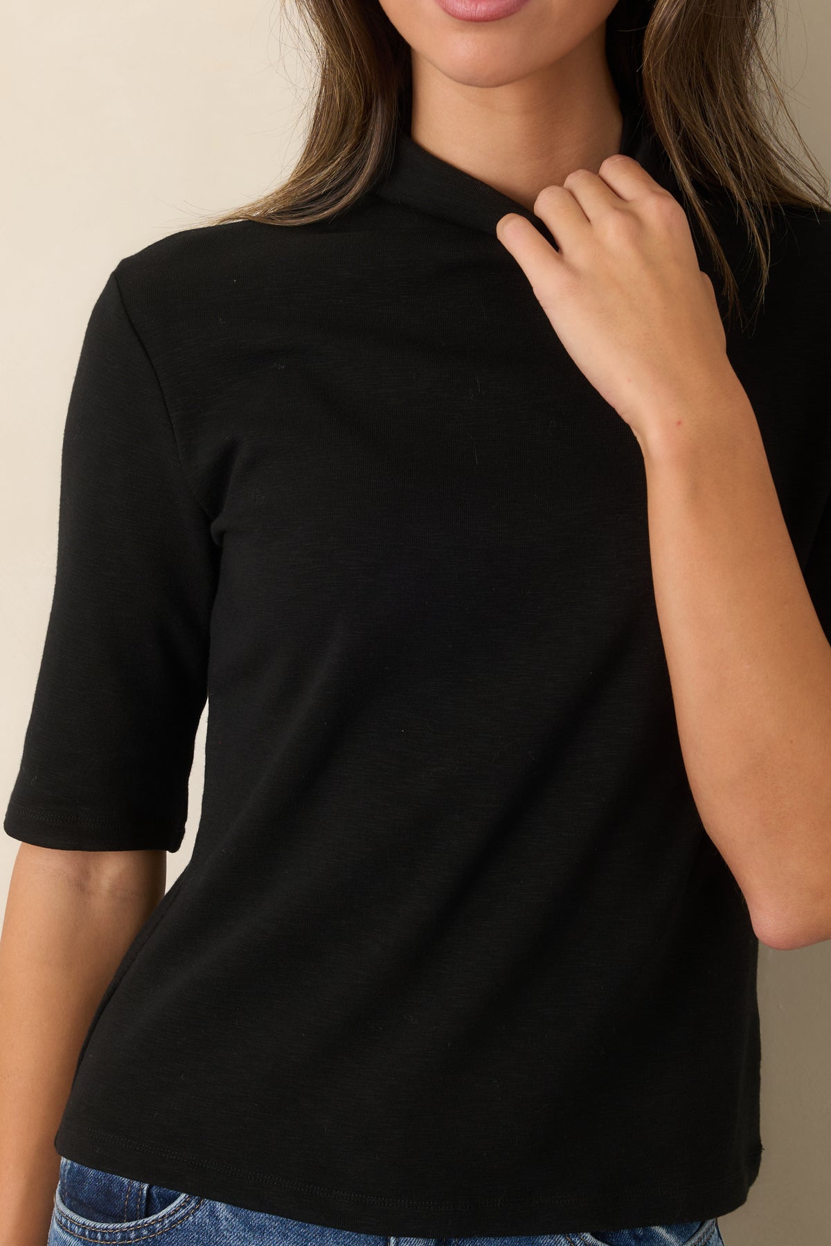 Close view of the soft knit texture and high turtleneck neckline.