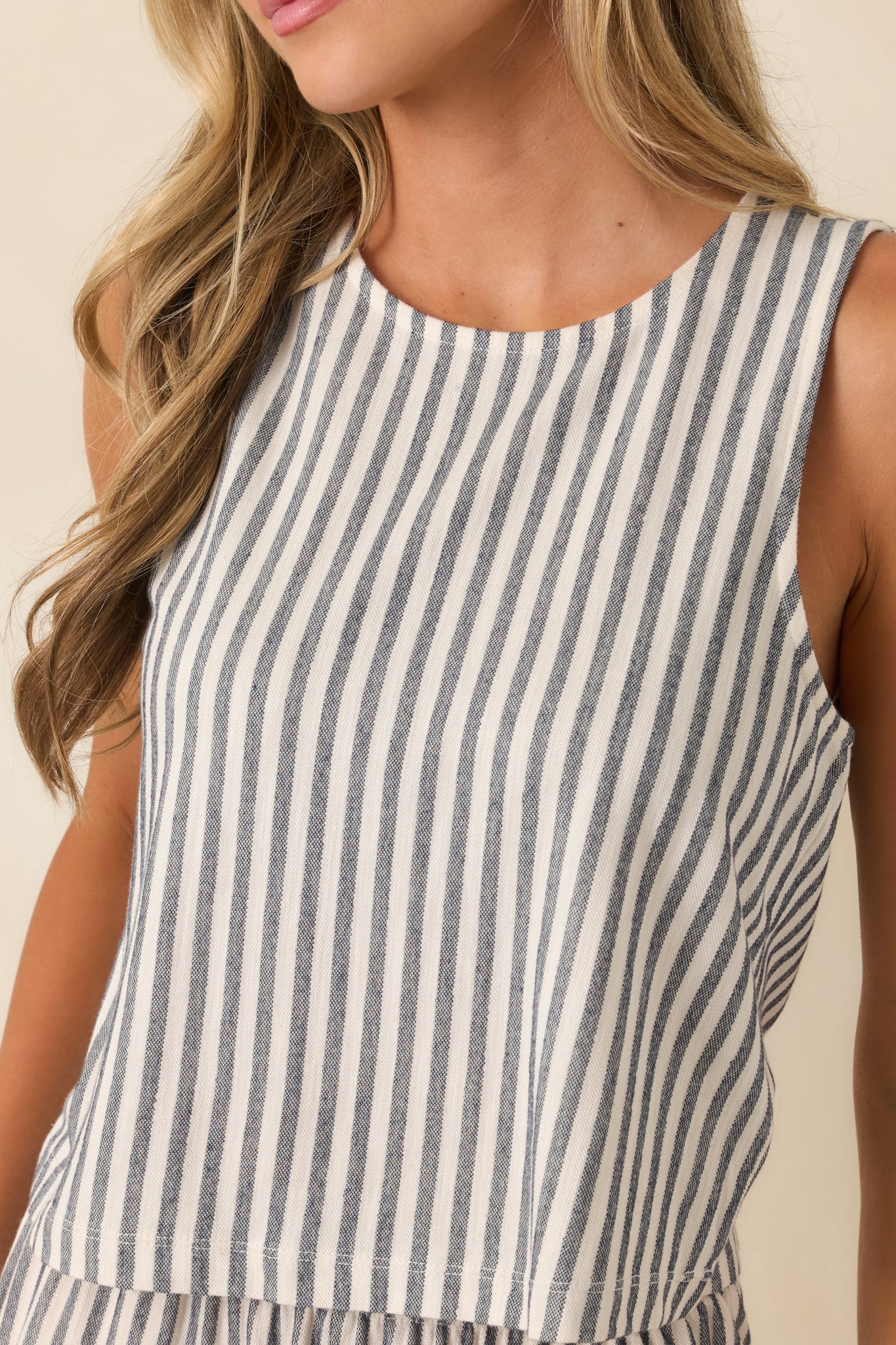 Close-up detail of the soft knit texture, vertical stripes, and refined neckline finish.