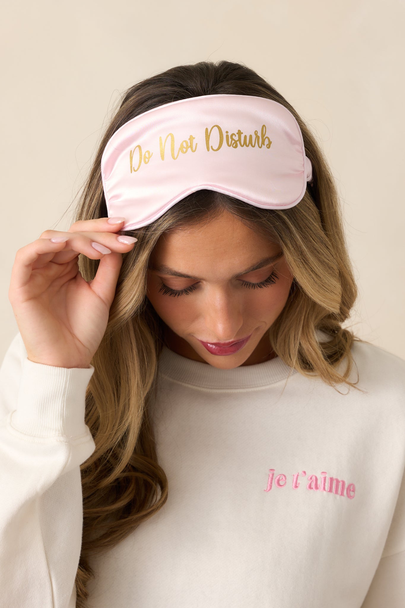 A soft pink eye mask highlighting its scrunched band, designed for a comfortable and adjustable fit.