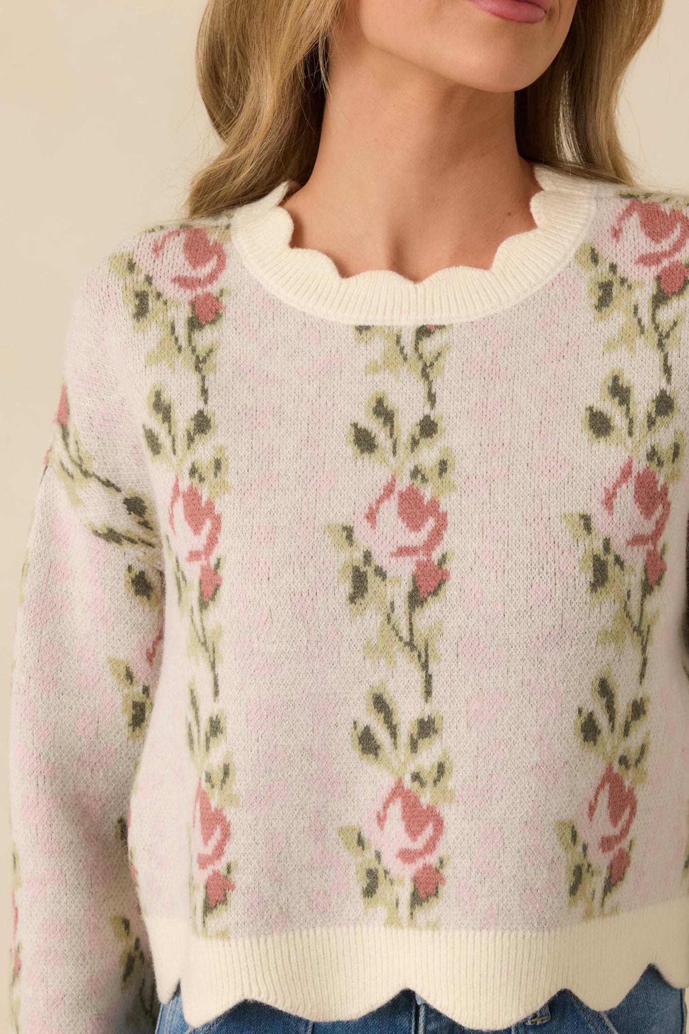Soft pink knit fabric with floral pattern and scalloped edge detailing.
