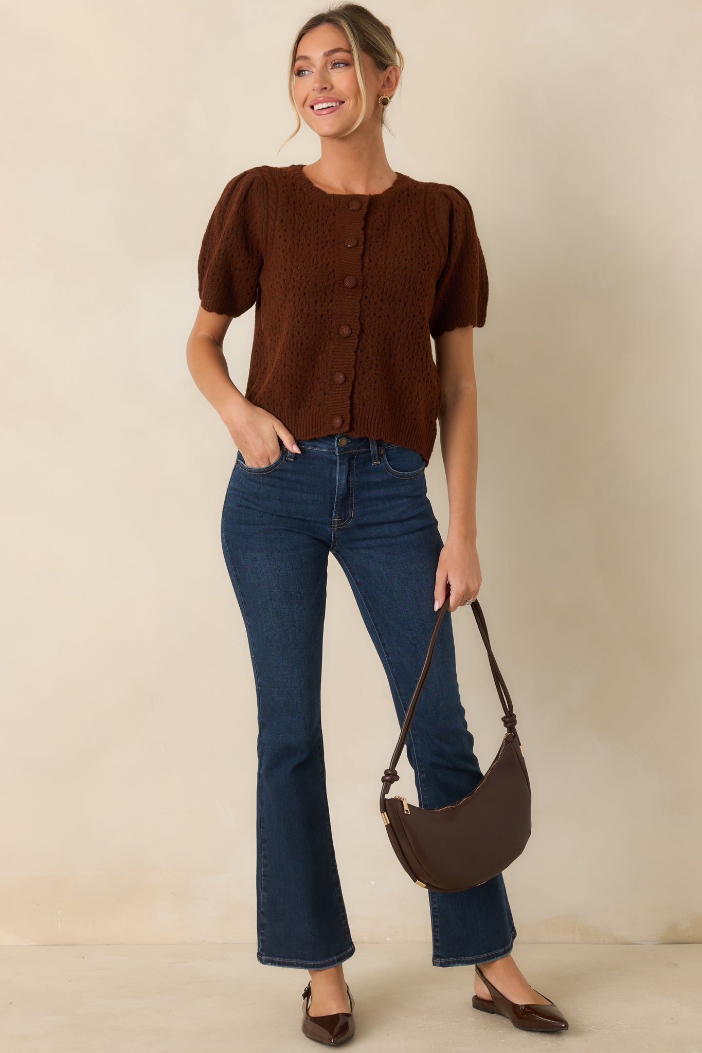 Soft pointelle knit cardigan featuring a classic crew neckline, fabric-covered front buttons, puffed short sleeves, and ribbed trim.
