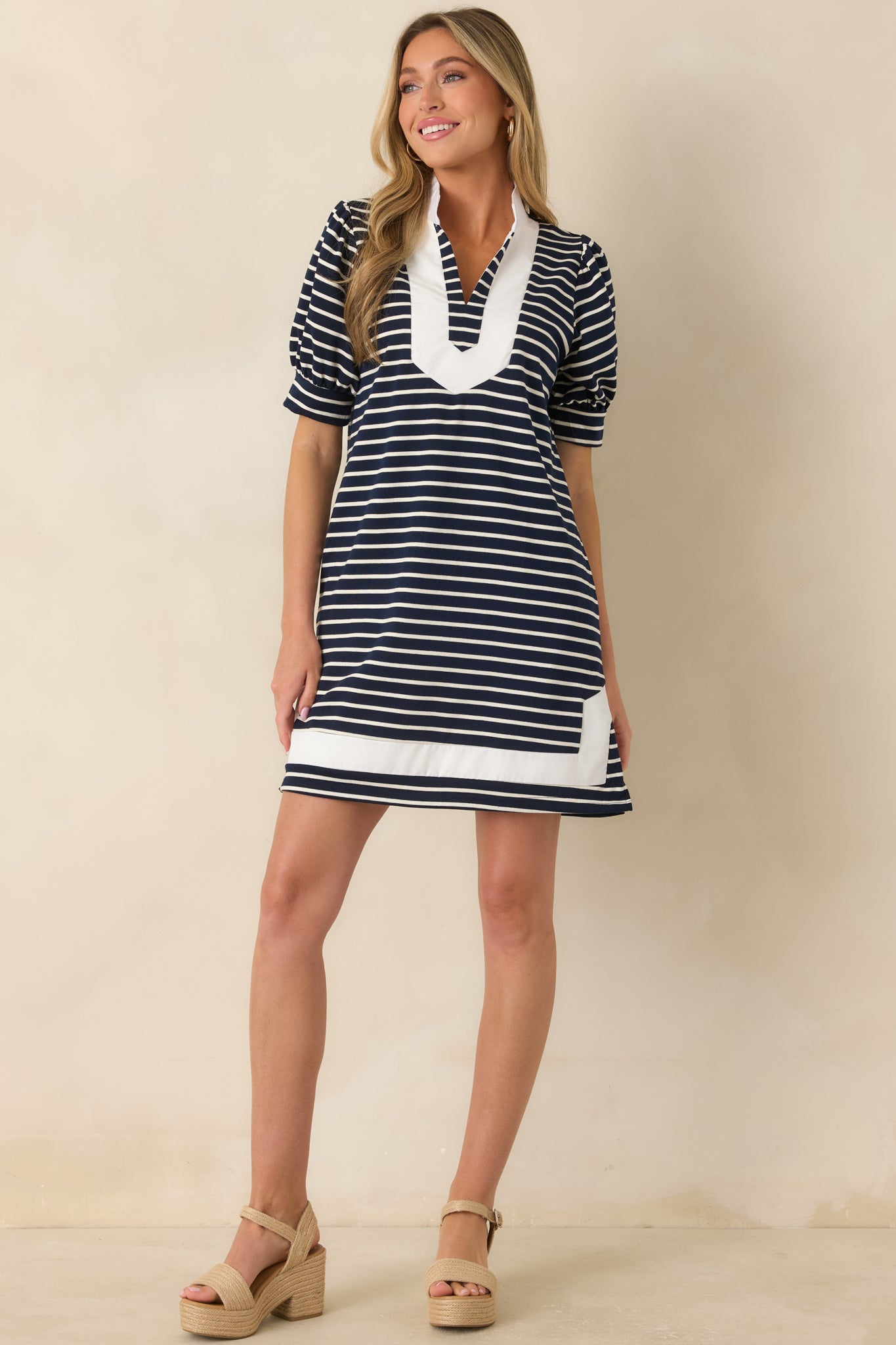 Soft striped shift dress designed with navy and white stripes, puff sleeves with banded cuffs, contrast trim, and a mini-length silhouette.