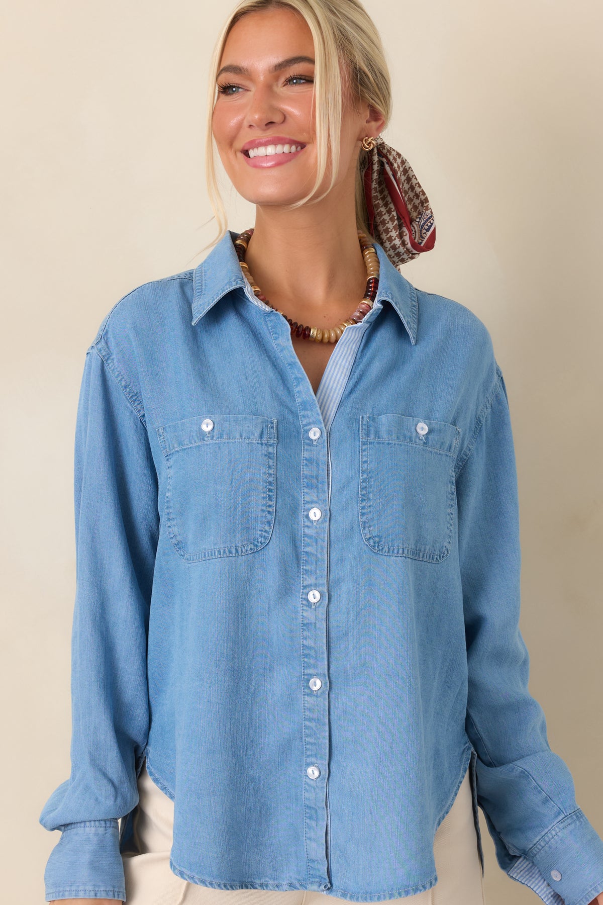 Soft-washed denim top highlighting the classic collar, button-front closure, and two spacious chest patch pockets.