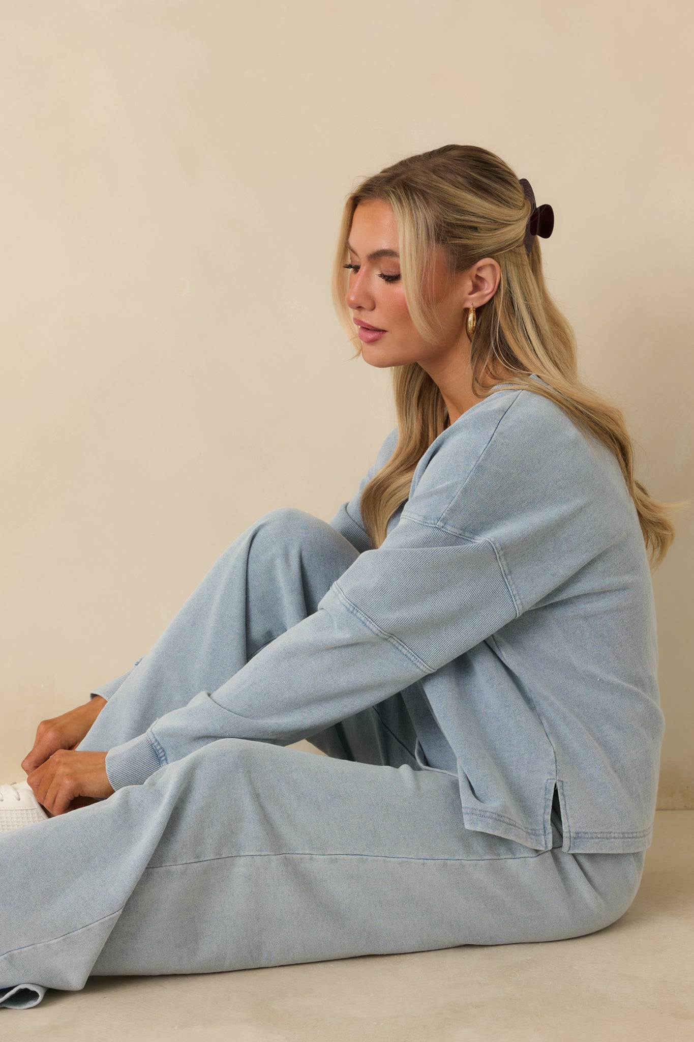 Soft-washed denim–style sweatshirt featuring a loose silhouette, cotton-blend fabric, and ribbed edges at sleeves and hem.