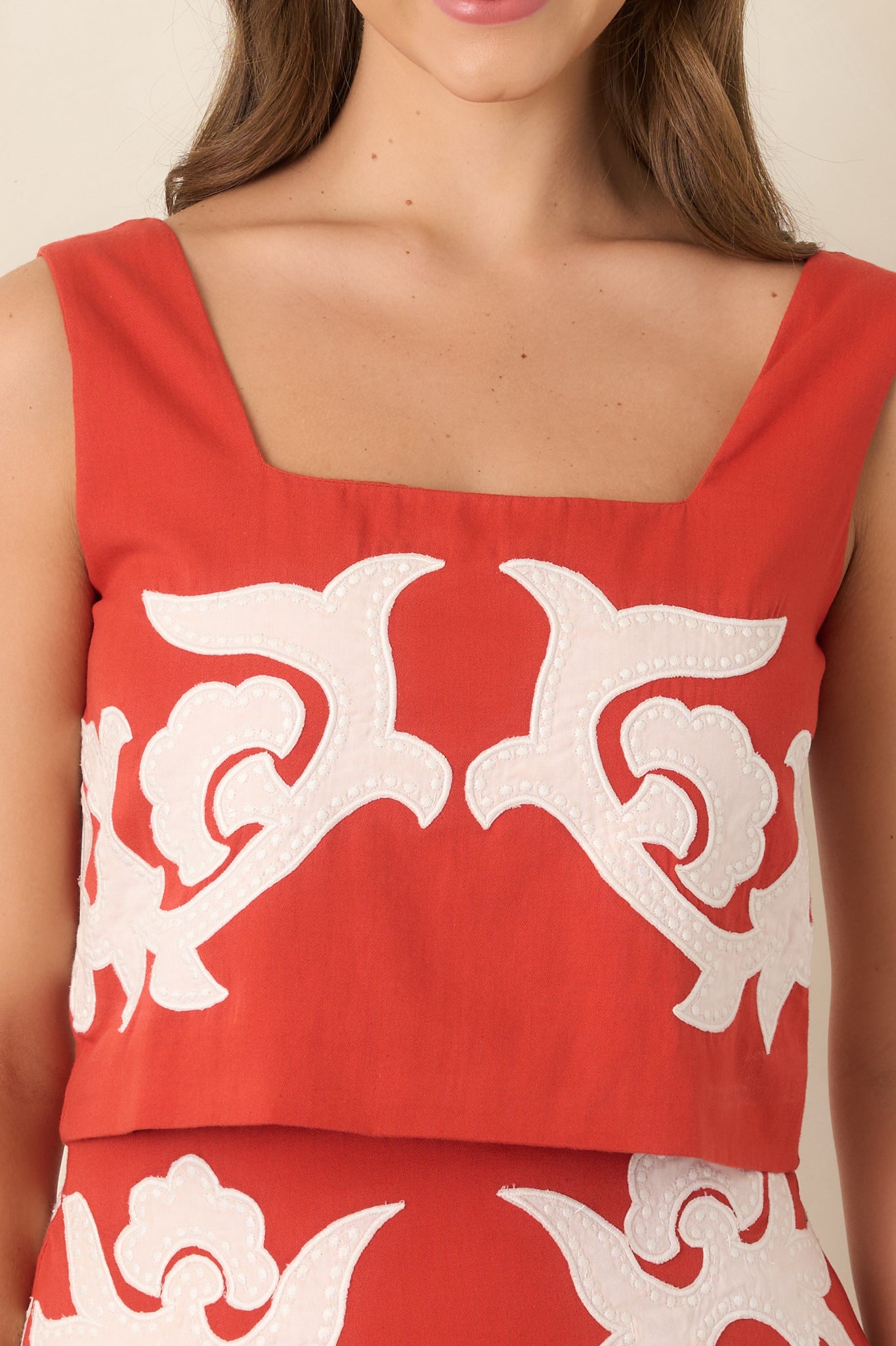 Close-up of the square neckline and wide strap construction, highlighting the smooth cotton fabric and clean finishing.