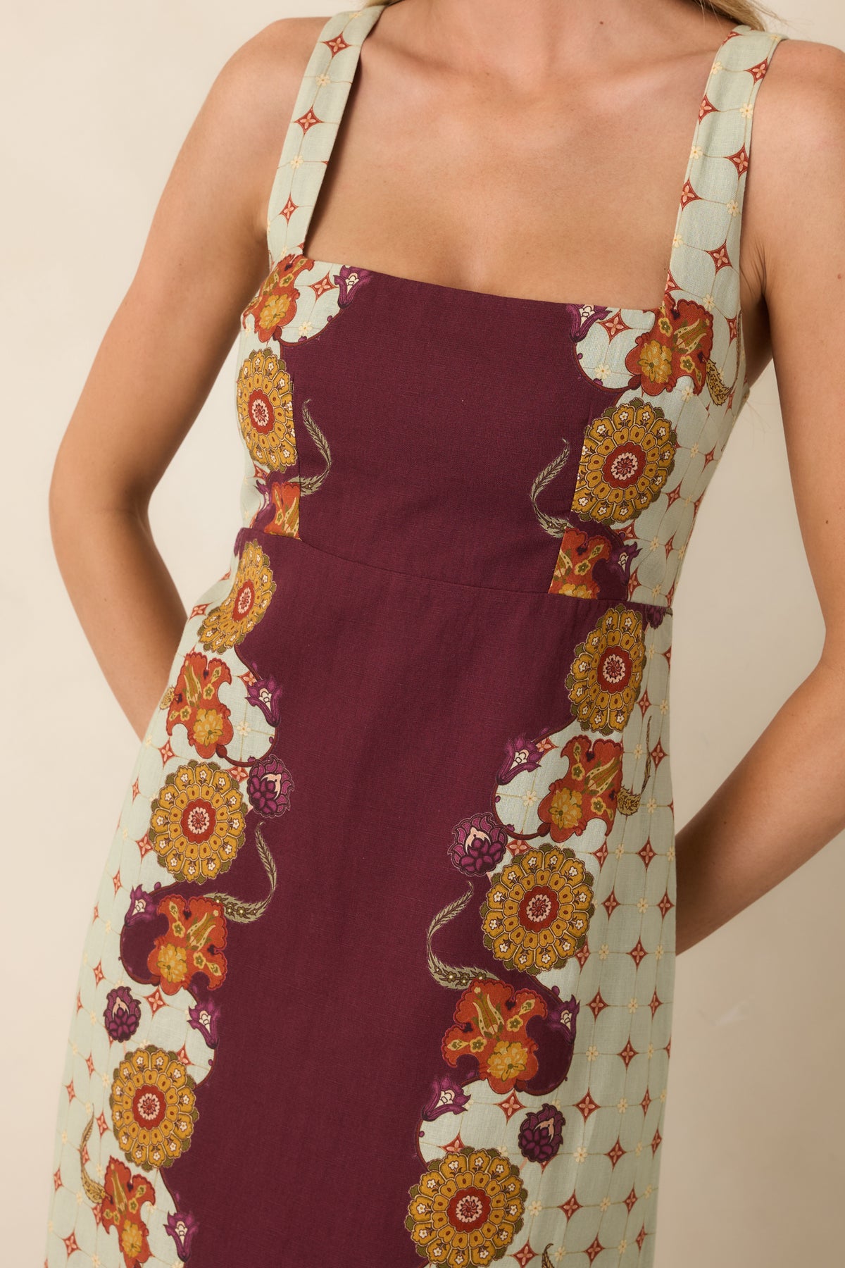 Close view of the square neckline, wide shoulder straps, and ornate floral print.