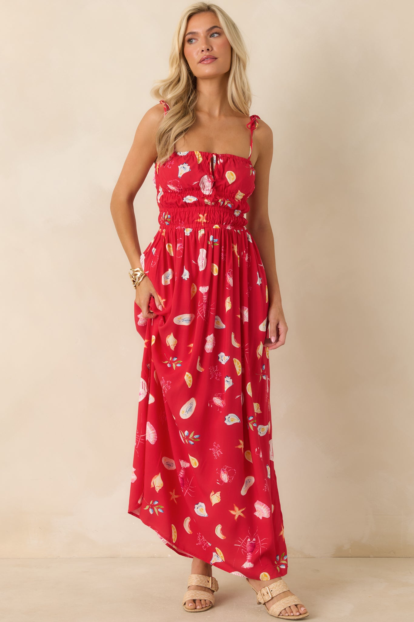 Maxi dress featuring a square neckline, adjustable tie straps, smocked bodice, and flowing skirt silhouette.