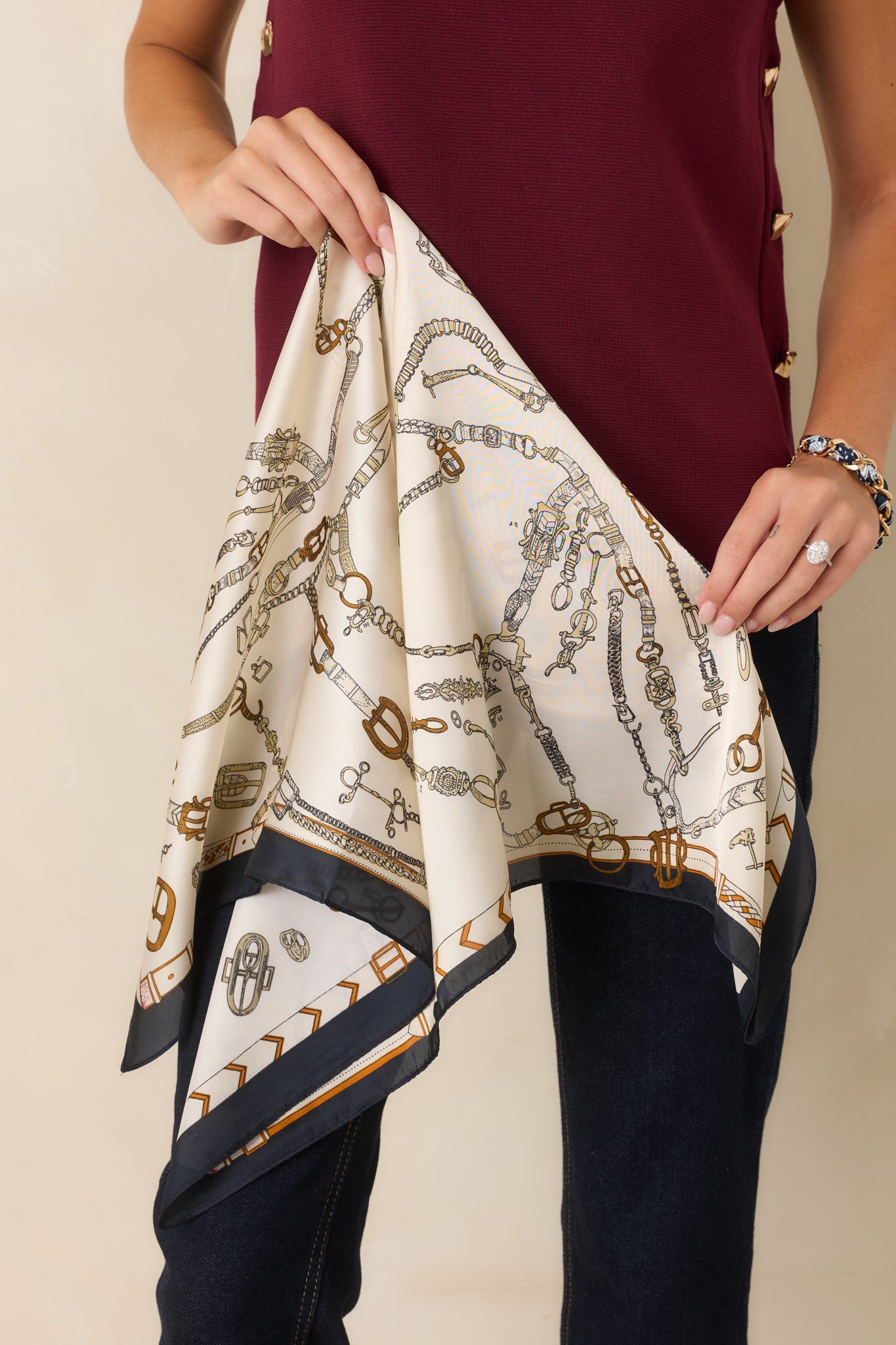 Square satin scarf showcasing a designer-inspired border surrounding an ornate mix of hardware motifs.