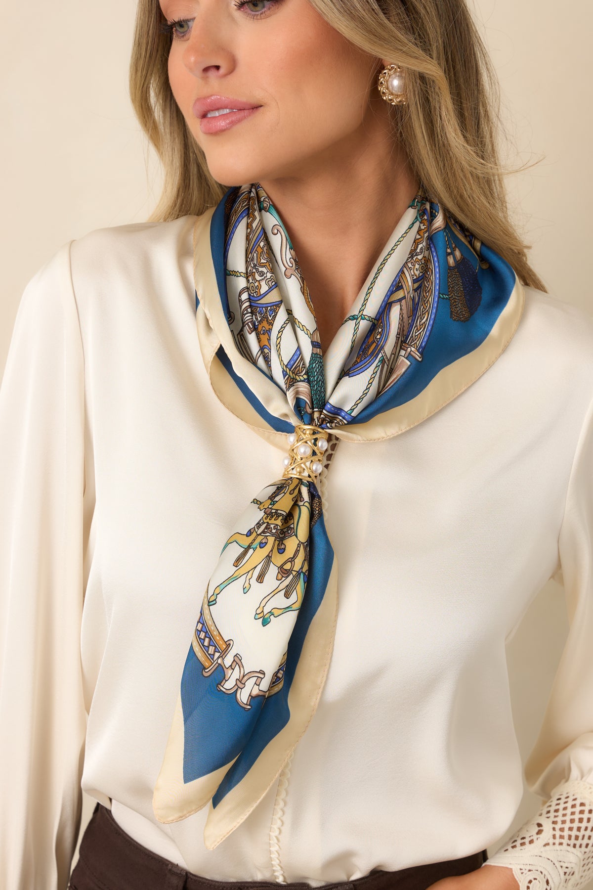 Decorative square scarf featuring intricate accessory motifs framed by a bold blue border and ivory edging.