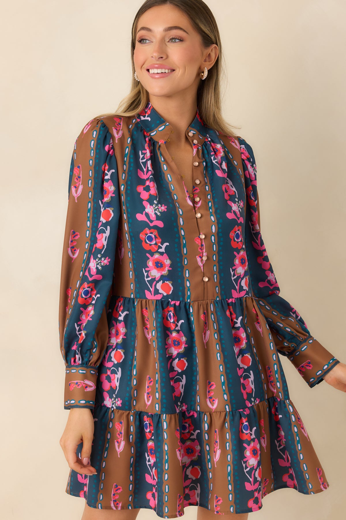 Stand collar and blush button front accent the teal and caramel striped floral mini dress.