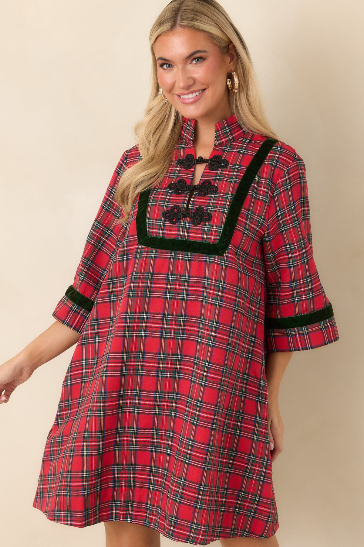Mini dress featuring a stand collar, red and green plaid pattern, and contrasting dark green velvet trim.