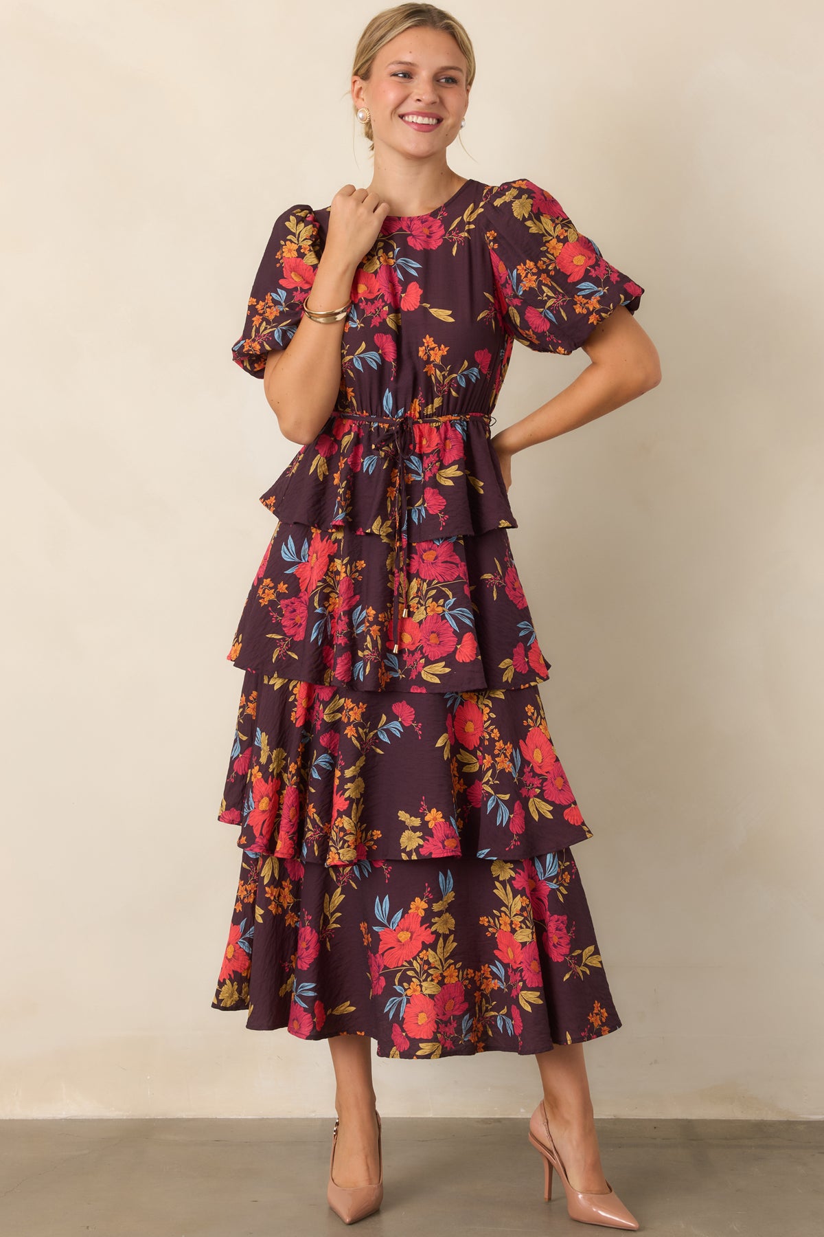 Statement maxi dress featuring a rounded neckline, puff sleeves, and layered A-line skirt.