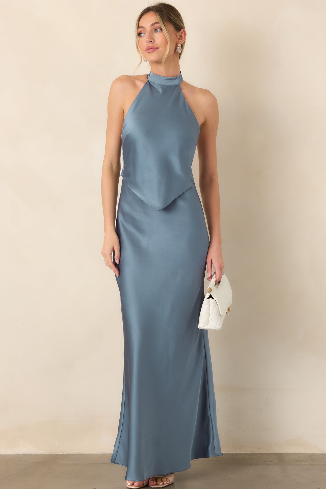 Steel blue satin maxi dress highlighting its sleek halter neckline, elegant bodice overlay, defined waist, and fluid floor-length drape.