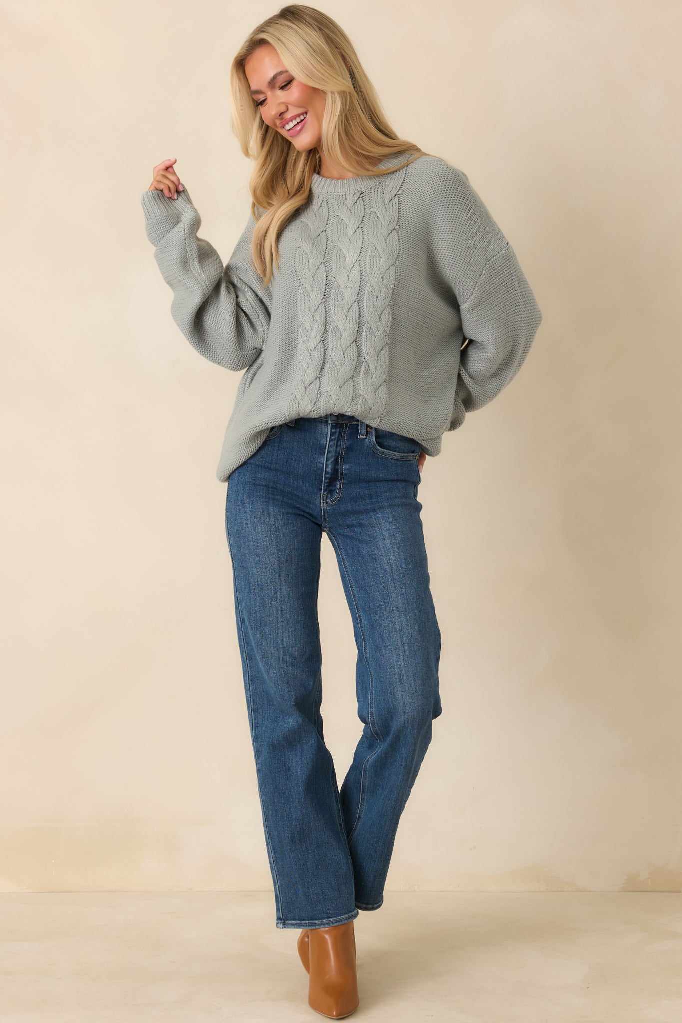 Stone blue cable knit sweater with a round neckline, drop shoulders, long sleeves, and a relaxed, easy-layering silhouette.
