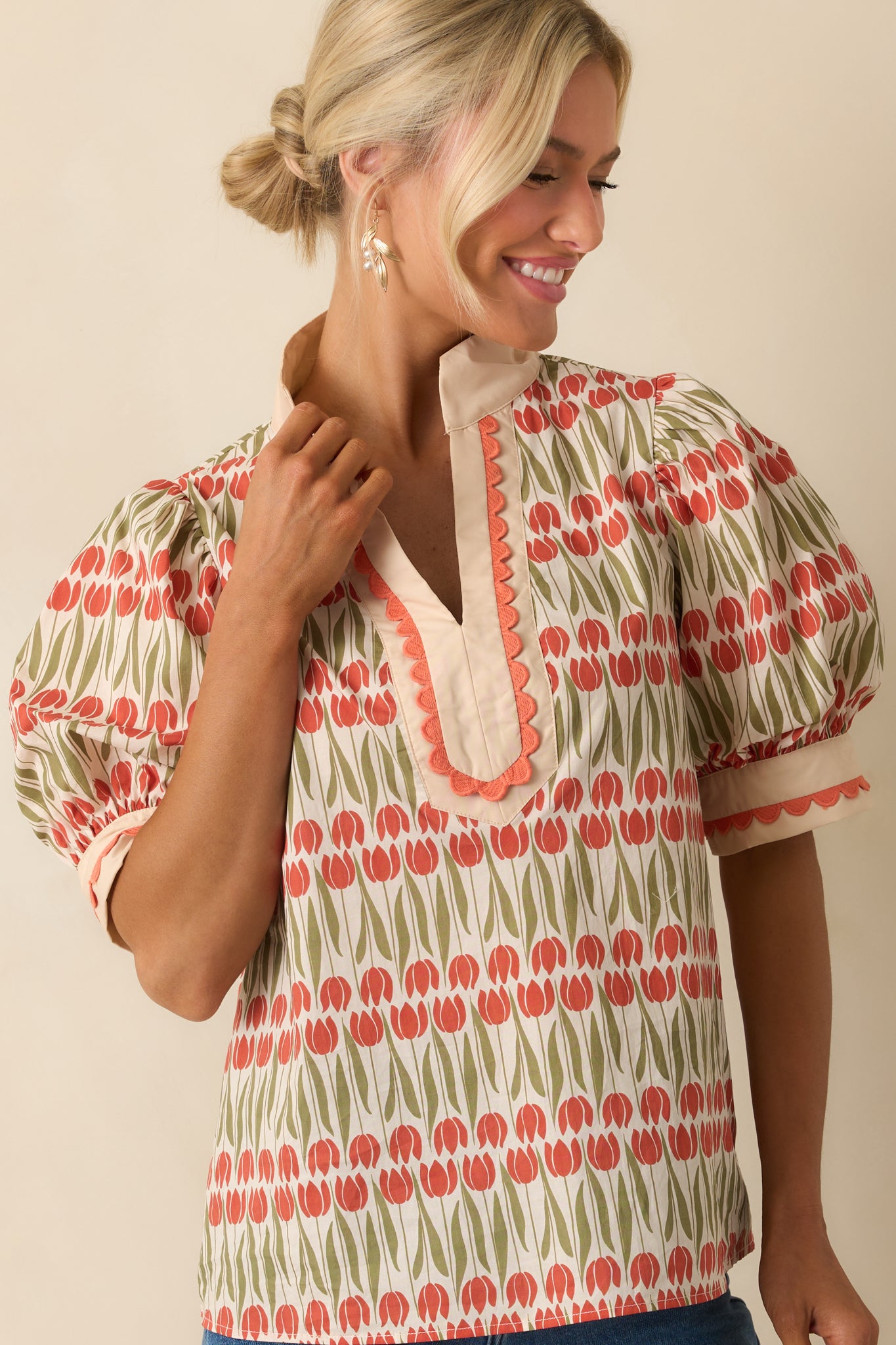 Straight hemline of the ivory tulip print blouse with subtle embroidered edging.