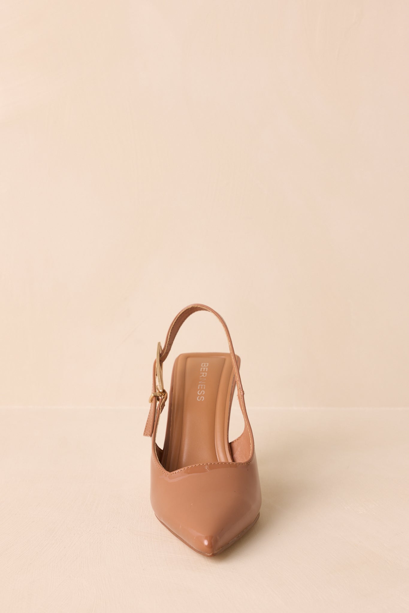 A straight-on shot of the brown heels highlighting the pointed toe and cushioned insole.