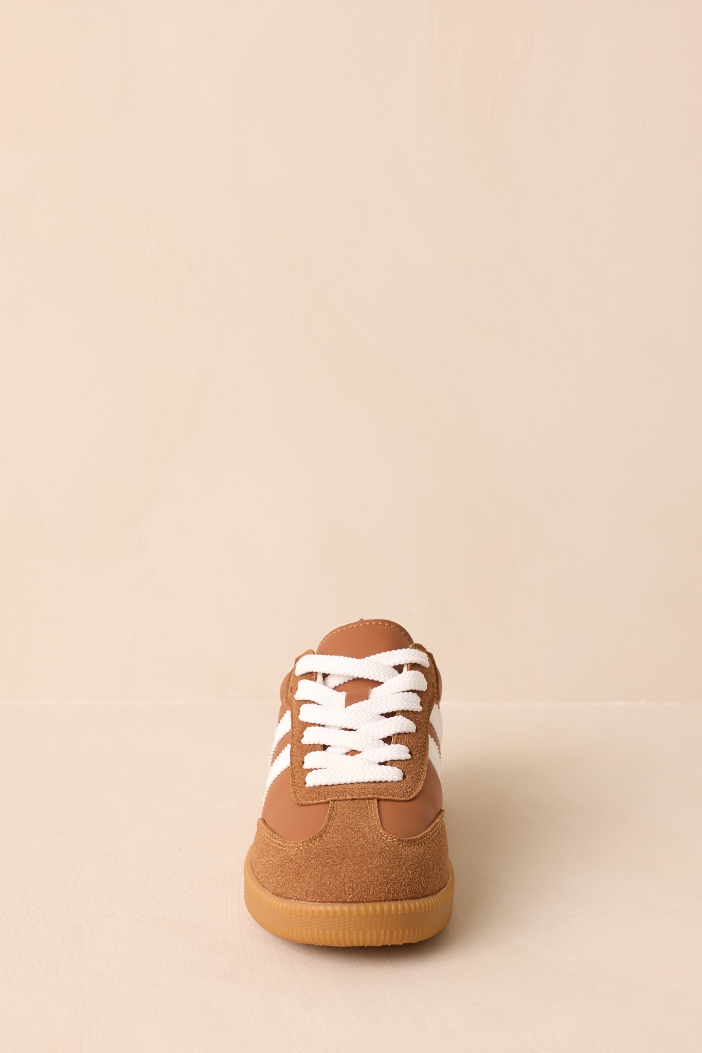 A straight-on front view focusing on the rounded toe with caramel brown faux suede overlay.