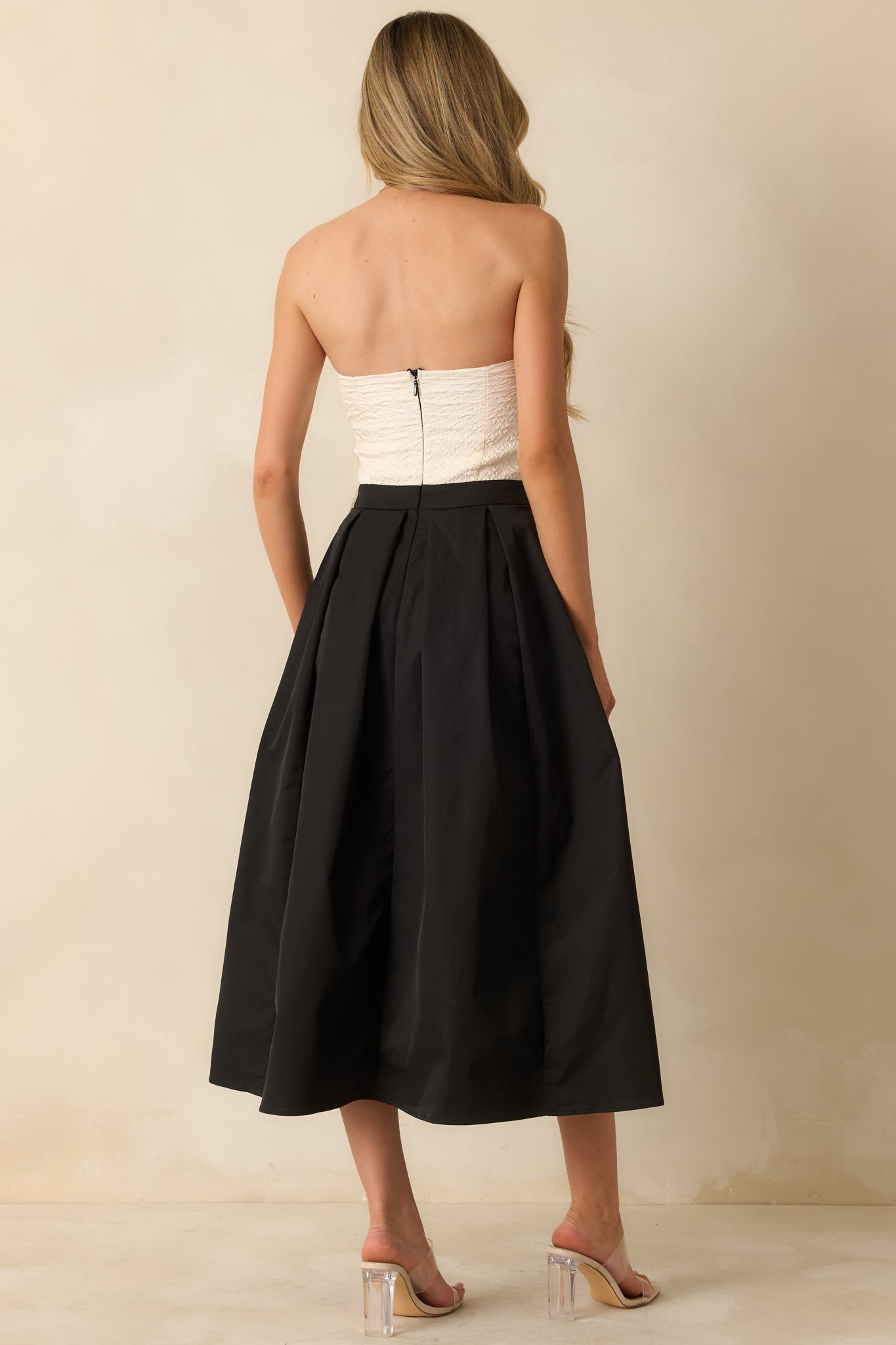 Rear view of the strapless maxi dress showing the secure back zipper closure and full pleated A-line skirt.


