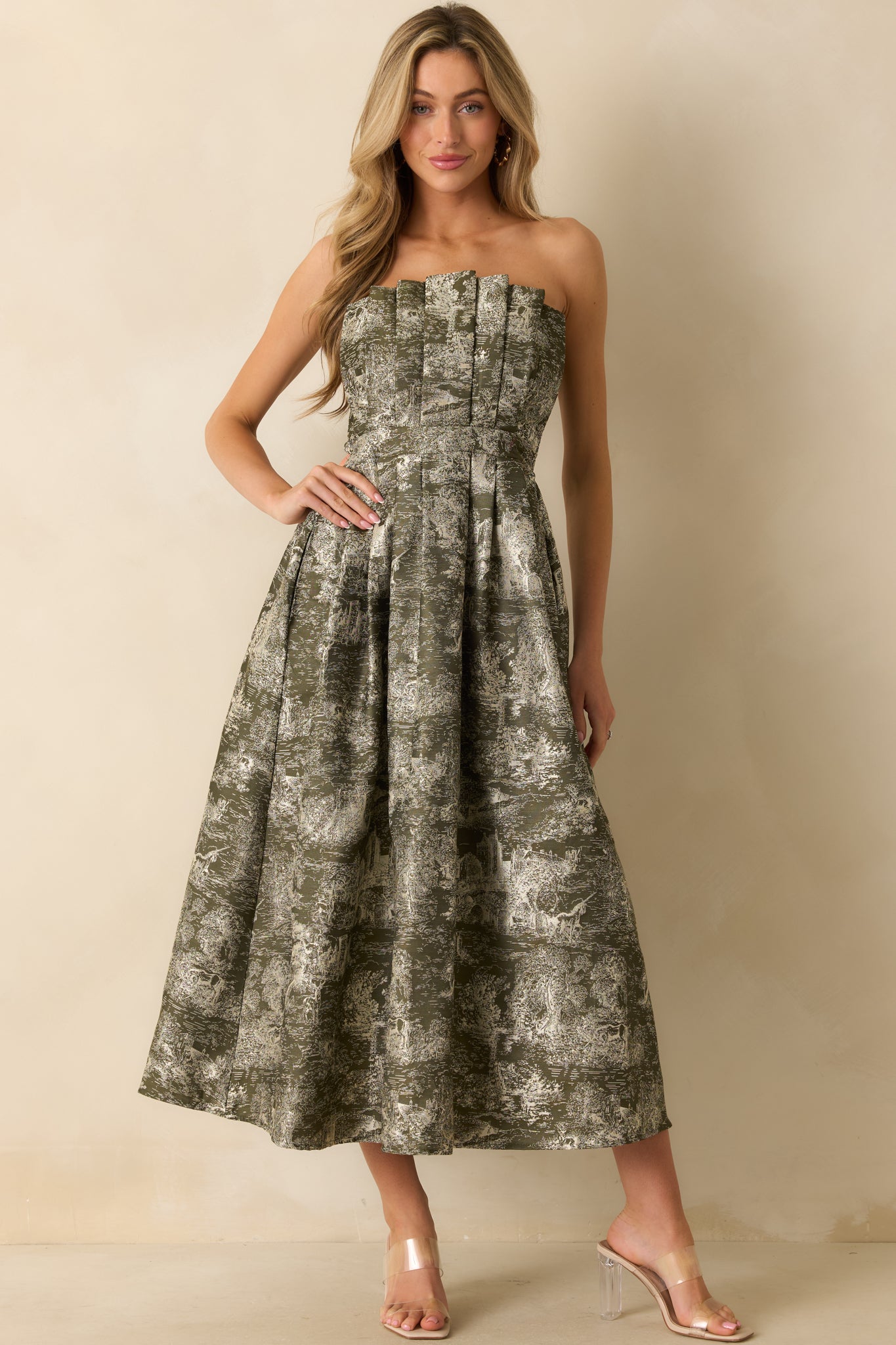 Strapless olive dress showcasing a detailed jacquard design, fitted pleated bodice, and full A-line silhouette.