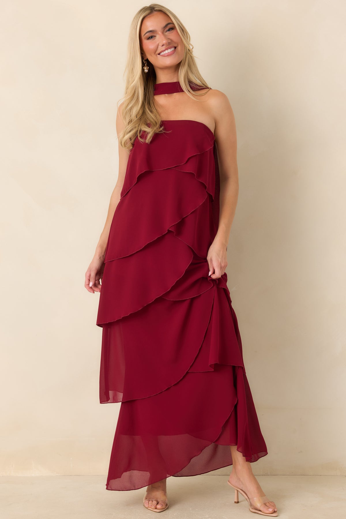 Strapless wine red dress with flowing ruffles creating movement throughout the skirt.