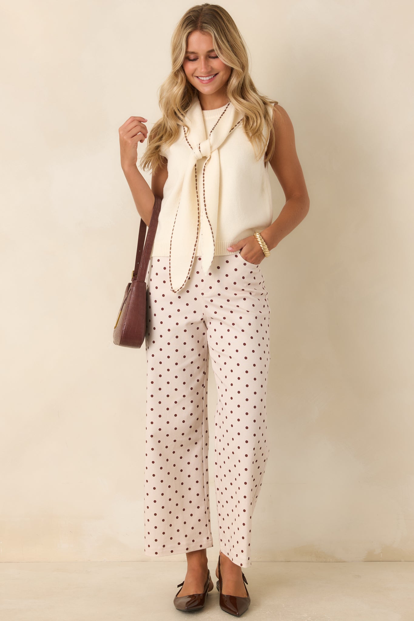 Stretch cotton blend pants designed with a flattering high-rise waist, elongated silhouette, and classic polka dot print.