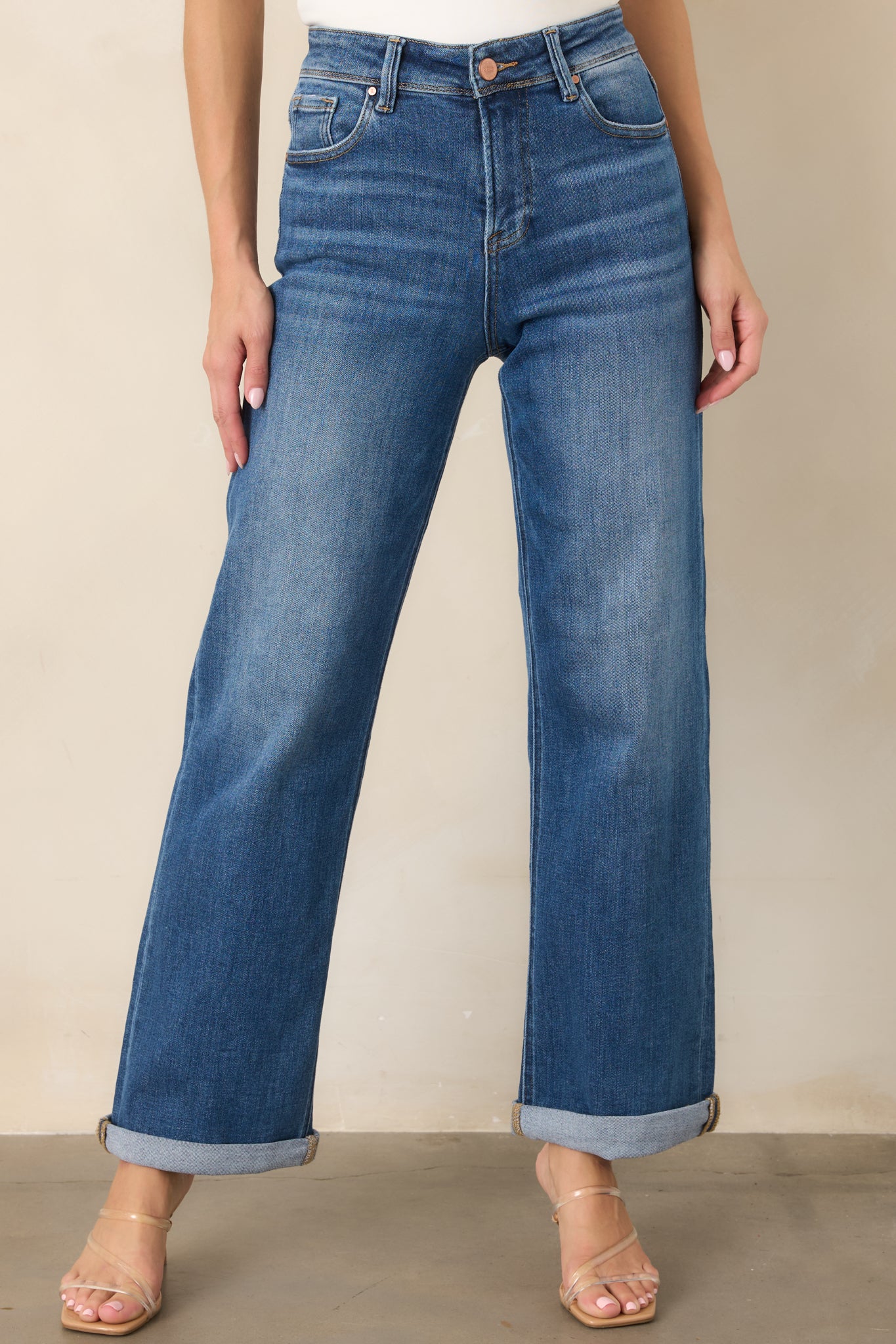 Close view of the stretch denim highlighting the waistband, belt loops, functional front pockets, and button-and-zip fly.