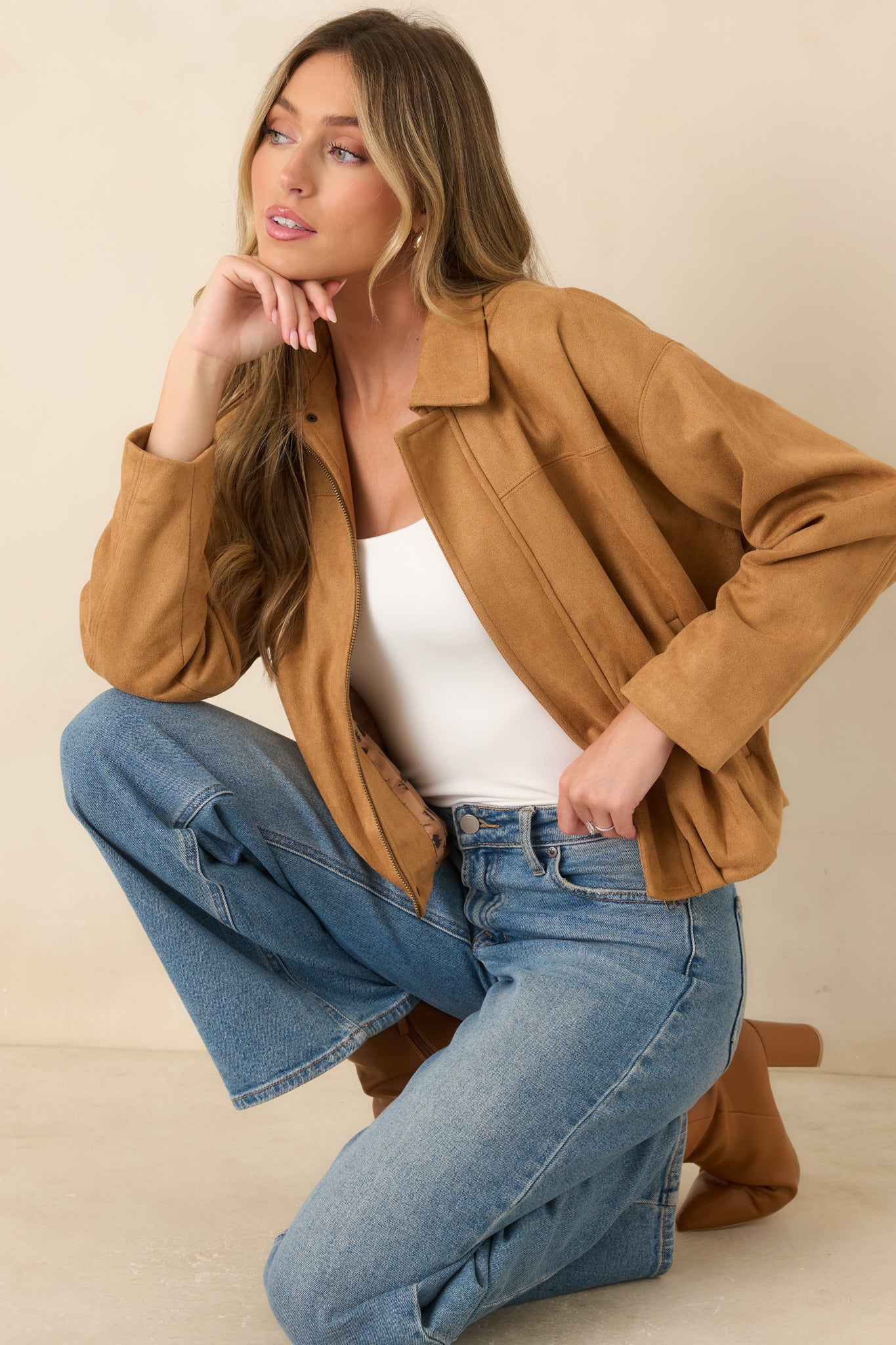 Stretch faux suede jacket featuring a pointed collar, concealed zip-front closure, dropped shoulders, and a gathered hem with a relaxed blouson silhouette.