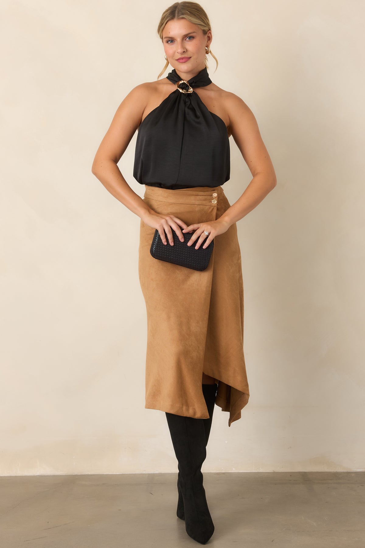Stretch faux suede skirt showcasing a polished wrap design, angled hem, and gold-tone button accents.