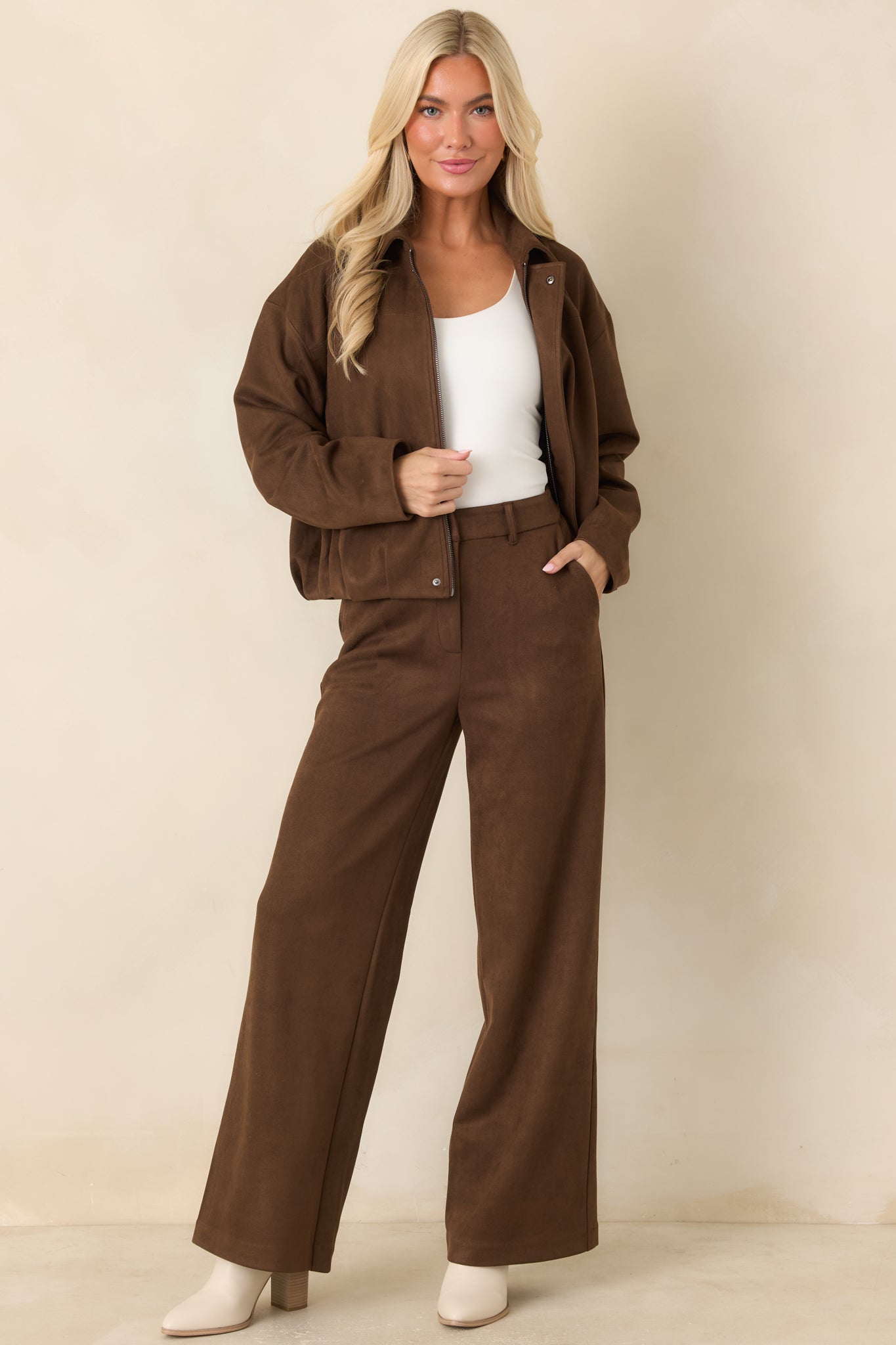 Stretch faux suede jacket with a pointed collar, smooth zip-front placket, dropped shoulders, and a softly gathered hem.