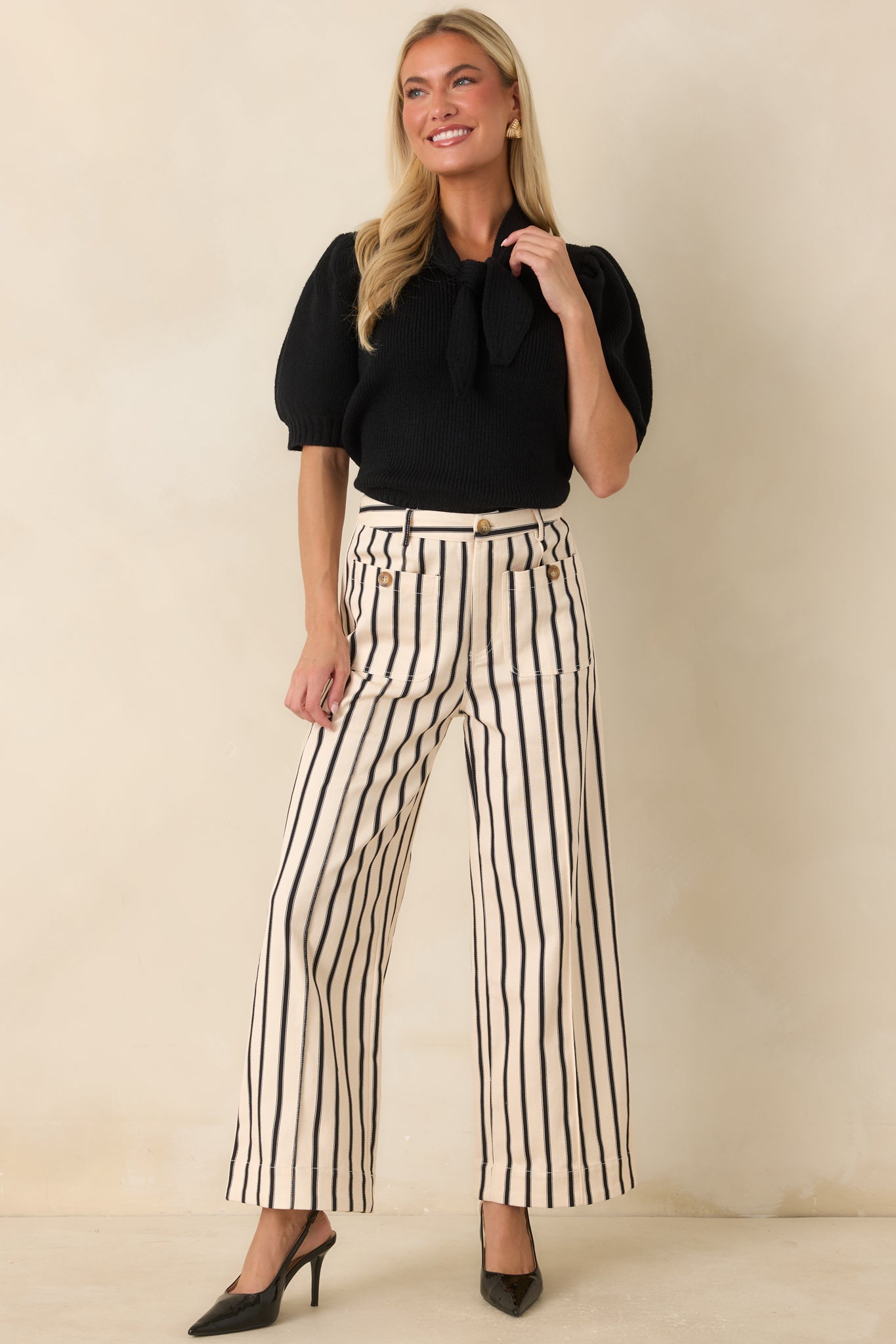 Stretch ribbed top featuring an oversized tie detail at the neckline and softly gathered sleeves with ribbed cuffs.