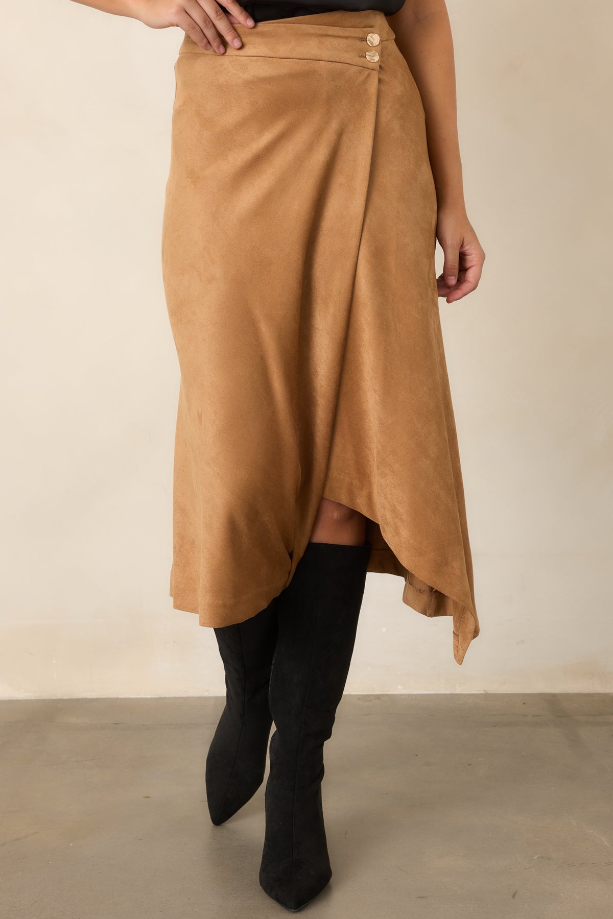Stretch suede skirt featuring two polished gold-tone buttons and an elegantly angled hem.