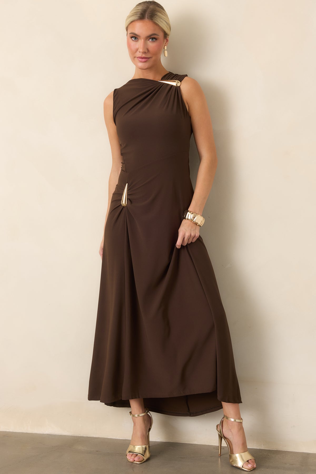 Stretchy fitted dress showcasing the asymmetrical draping and sculptural gold-tone teardrop detail at the hip.
