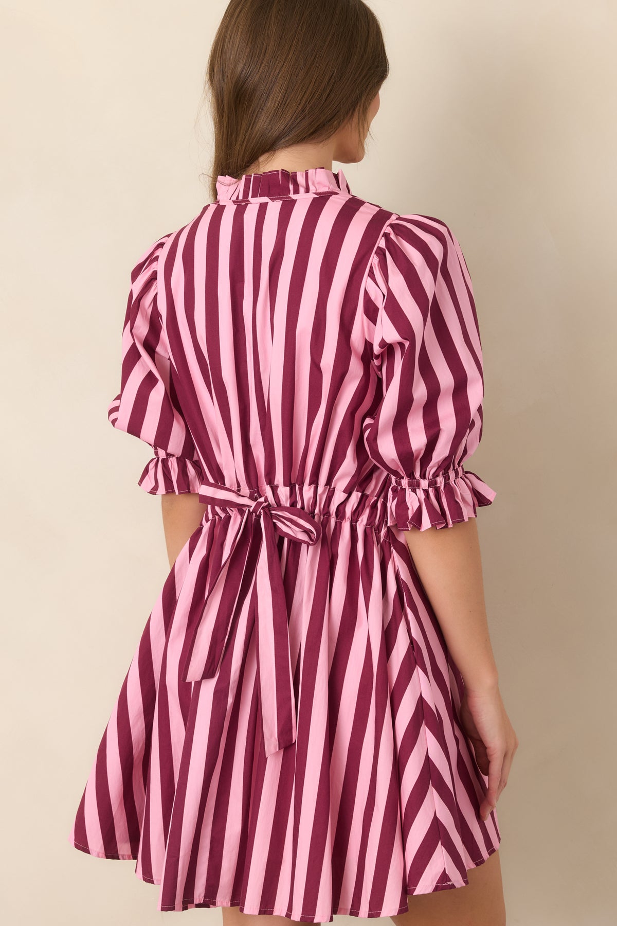 Rear view of the striped cotton mini dress showcasing the adjustable drawstring tie-back waist and relaxed shift silhouette.