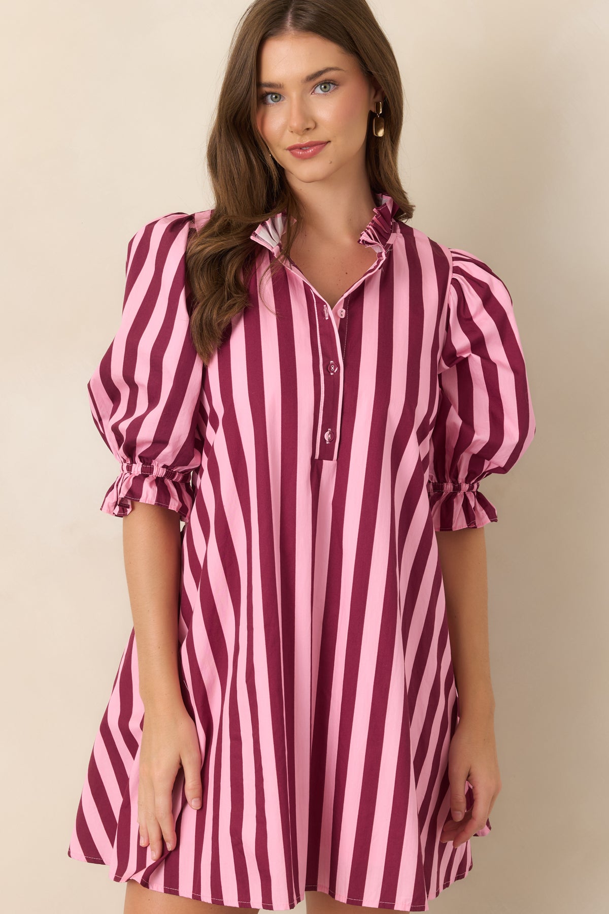 Close view of the striped cotton dress highlighting its ruffled mock collar, partial button-front placket, and softly gathered puff sleeve.