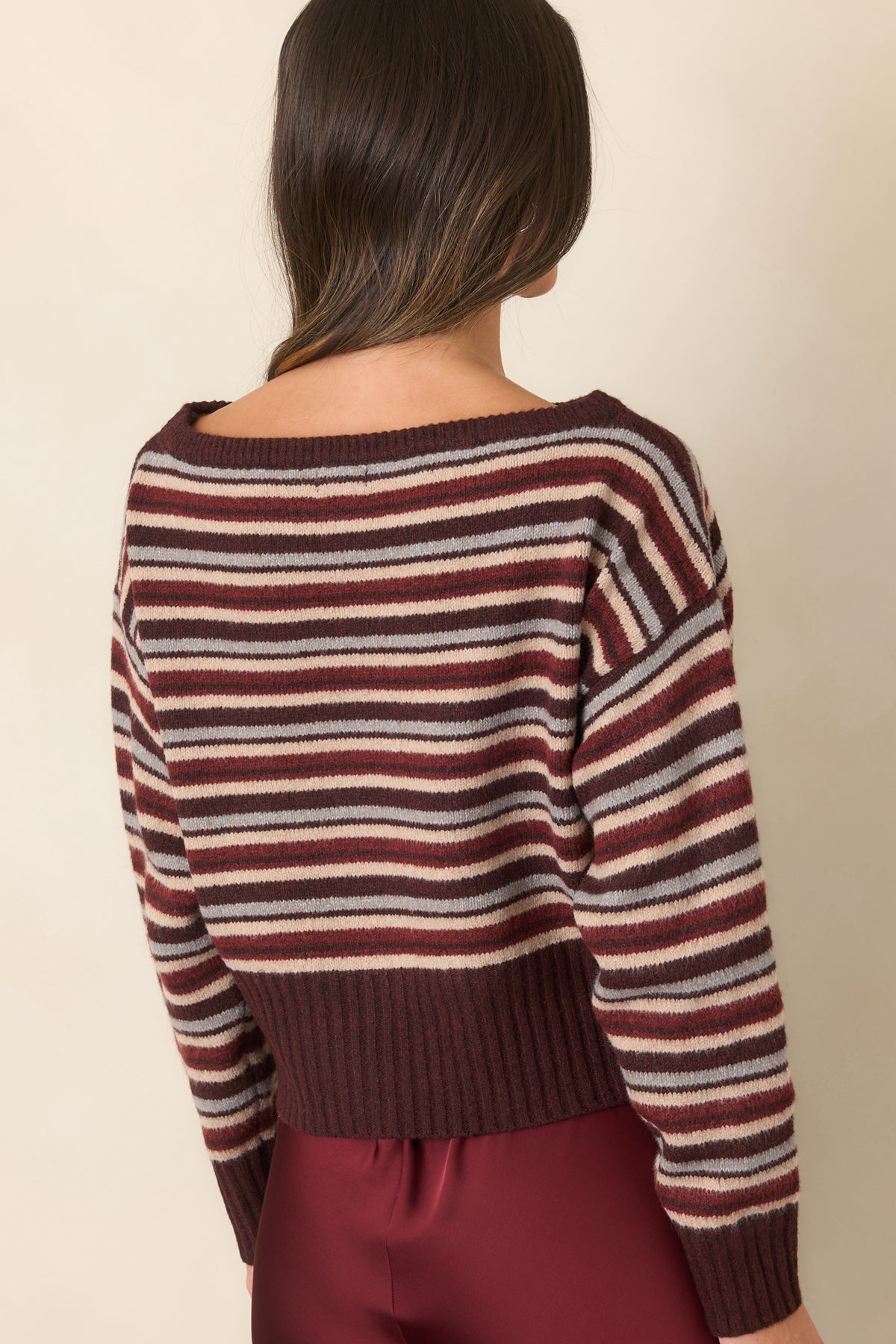 Striped knit top showcasing the relaxed dropped-shoulder silhouette and wide neckline from the rear.