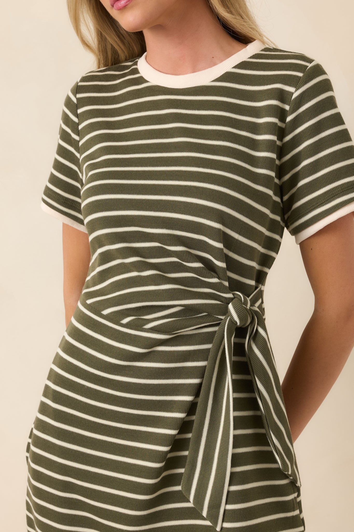 Close-up of the striped knit fabric featuring contrast trim, clean horizontal stripes, and the wrap-style side tie detail.