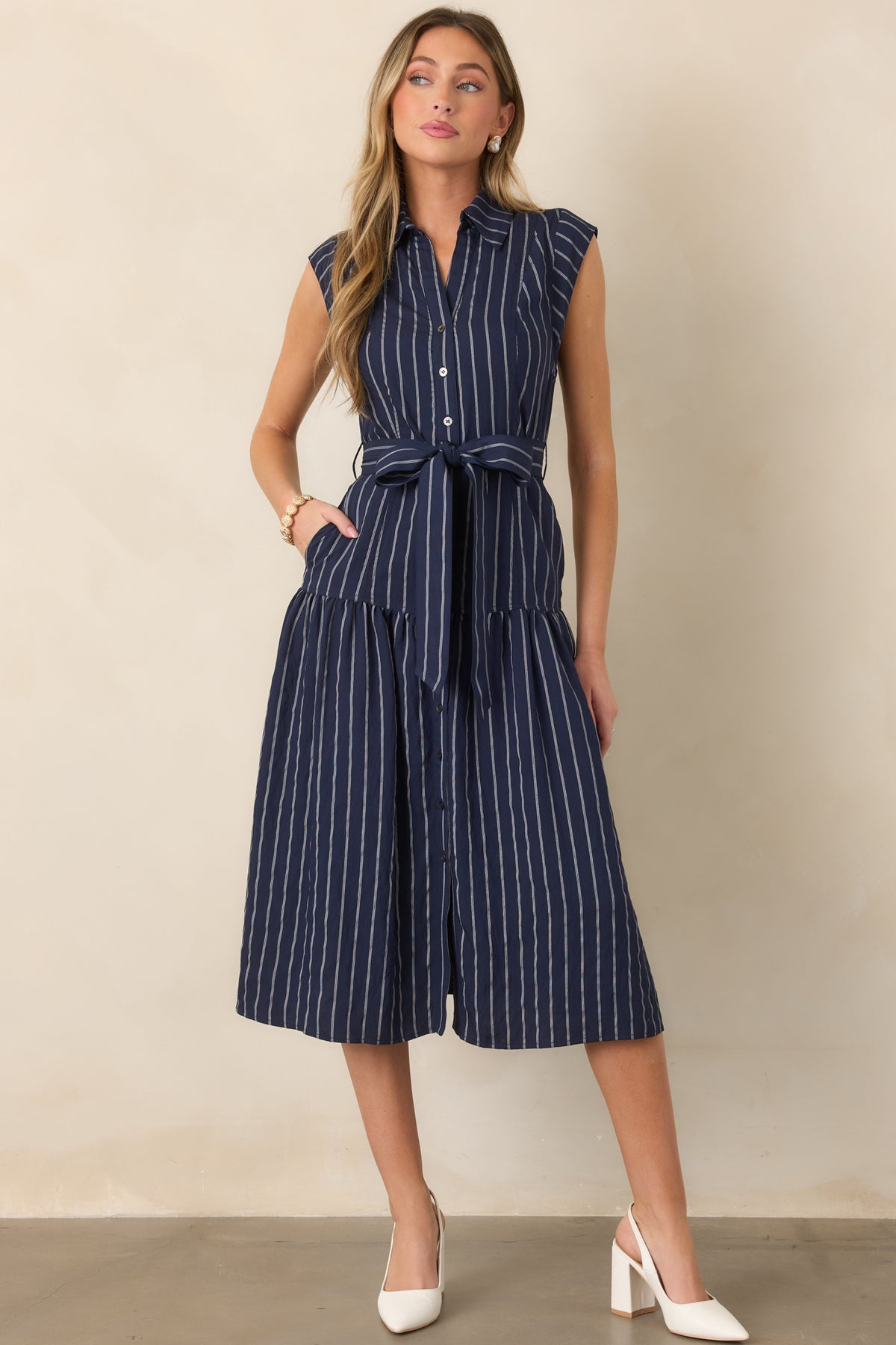 Striped midi dress featuring a polished collared neckline, cinched self-tie waist, and graceful drop-waist skirt.