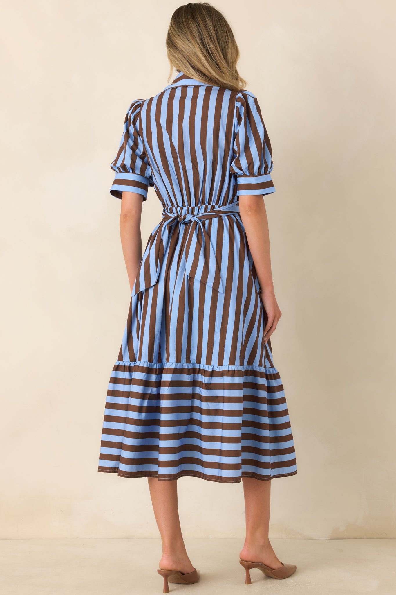Rear view of the cotton midi dress showcasing the wraparound waist ties secured at the back, elastic waistband, gathered skirt, and contrasting horizontal-striped lower tier.