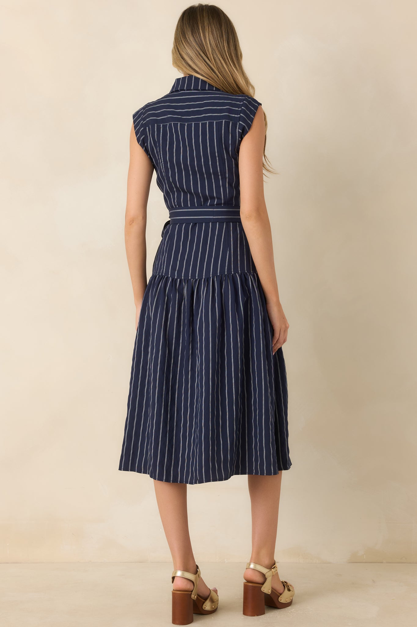 Rear view of the striped midi dress featuring a flowing full skirt, drop-waist seam, and lightweight fabric.
