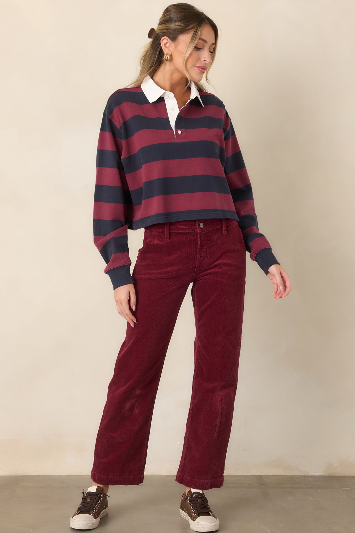 Striped rugby polo top featuring a classic white point collar, partial button-front placket, relaxed long sleeves, and a straight cropped hem.