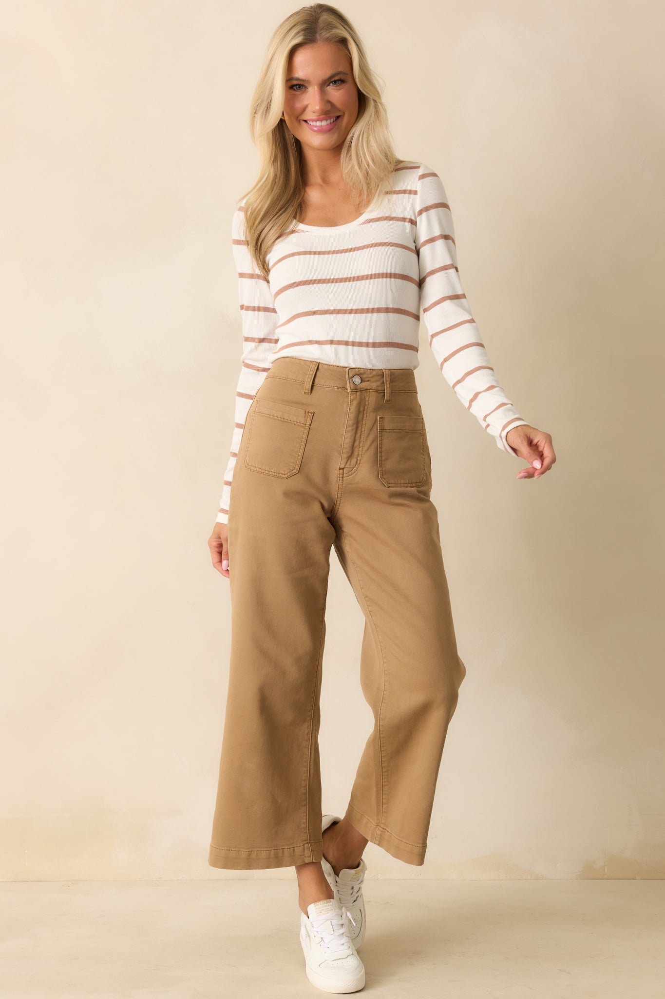 Striped top featuring long sleeves and a gentle scoop neckline in a white and caramel palette.